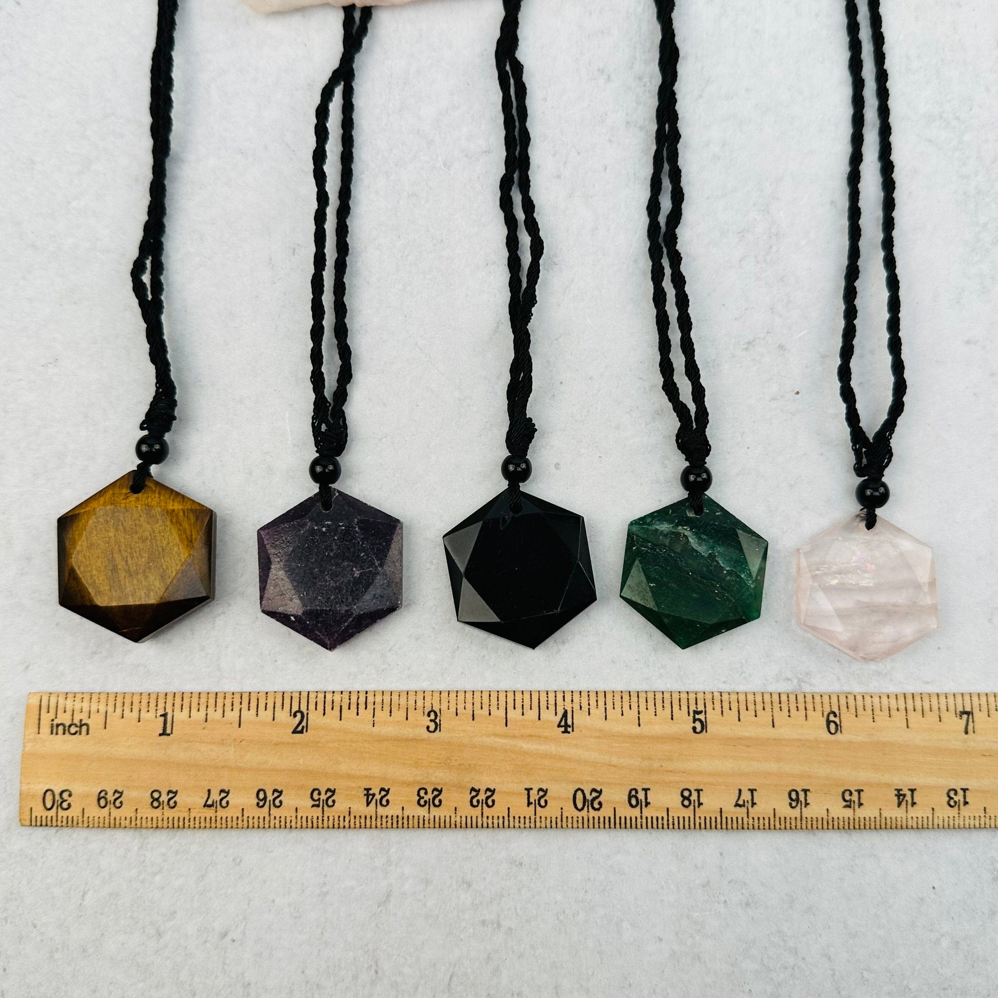 pendants next to a ruler for size reference 
