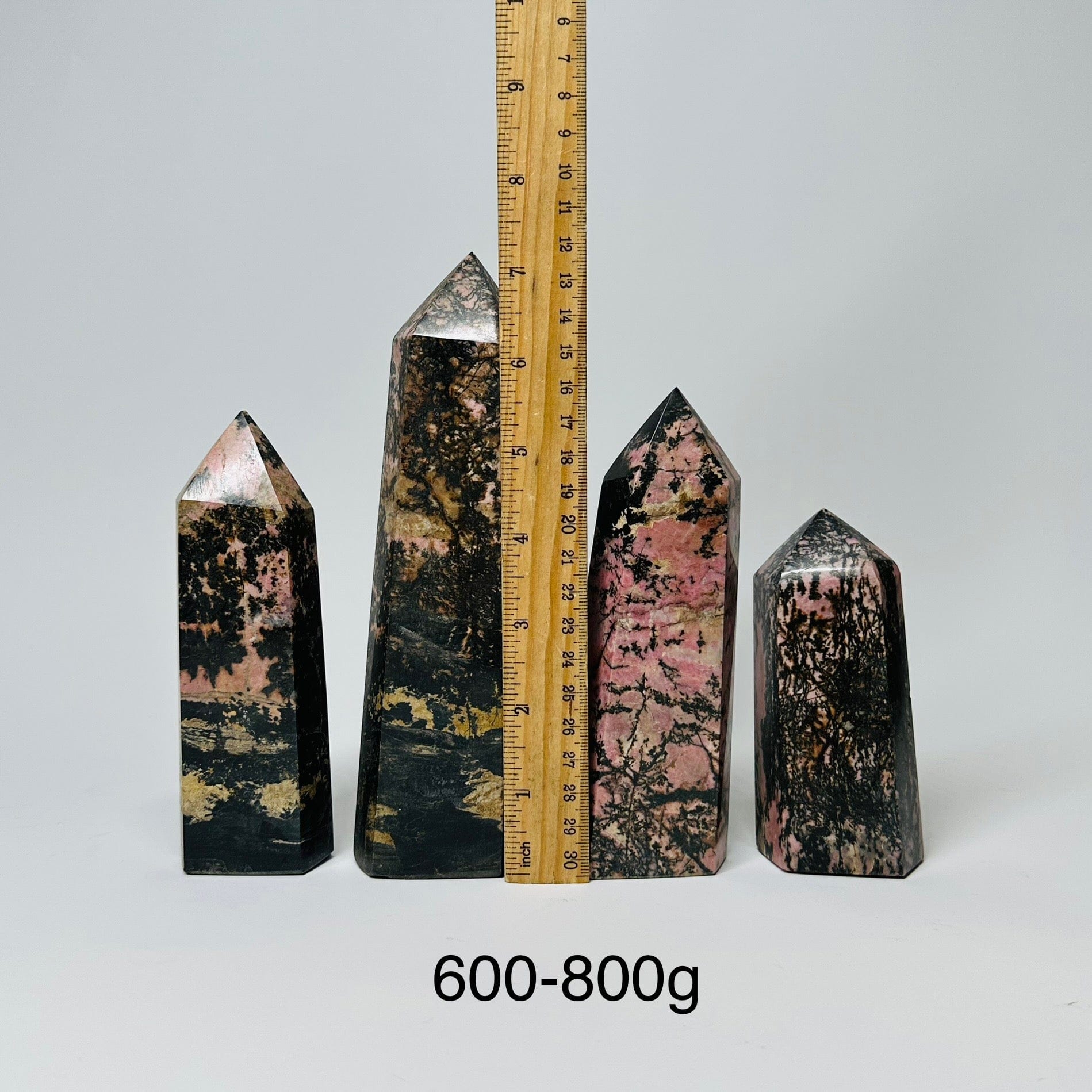 Rhodonite Crystal Polished Points - By Weight - displayed next to a ruler for size reference 