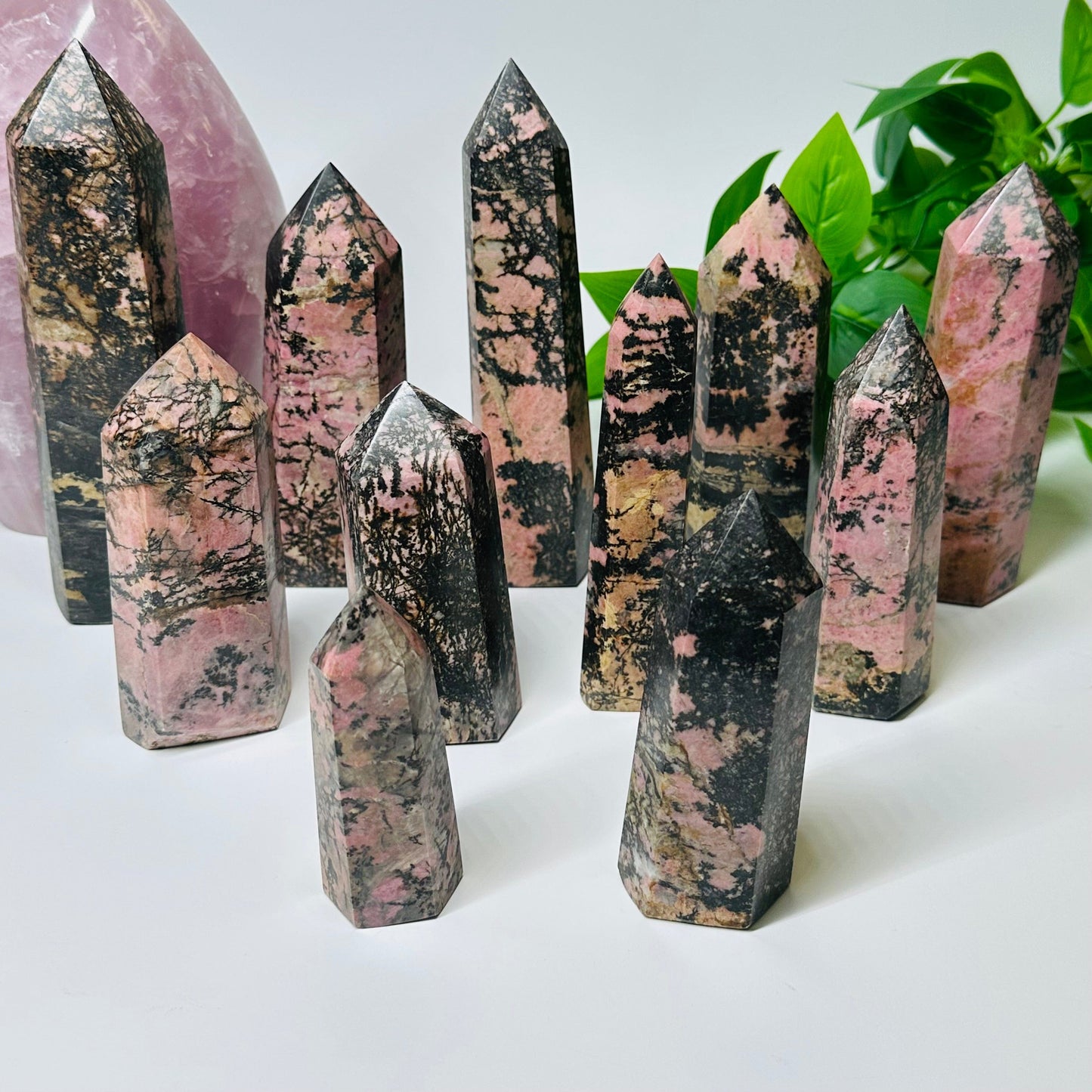 multiple Rhodonite Crystal Polished Points - By Weight - displayed to show the differences in the sizes and color shades 