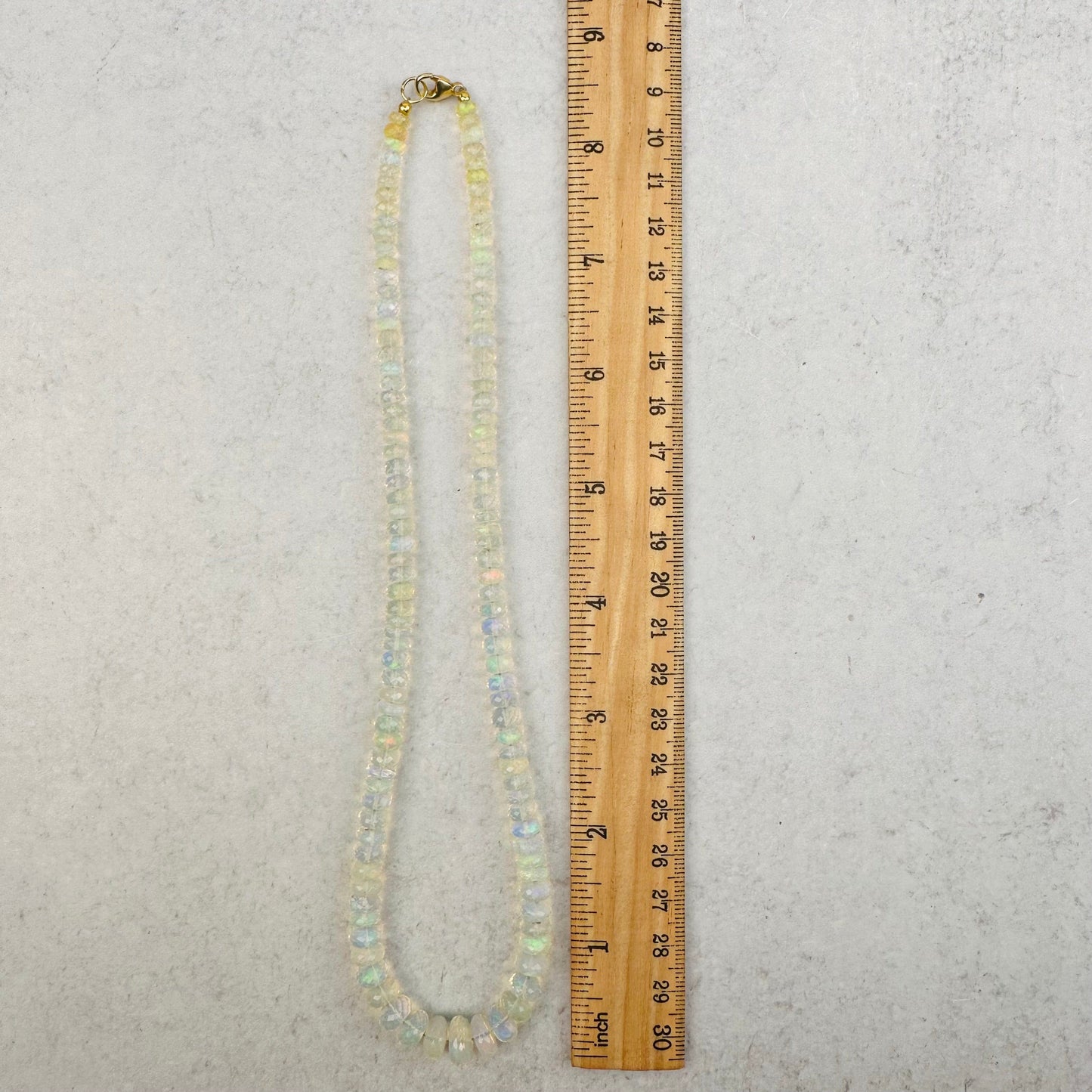 necklace next to a ruler for size reference 