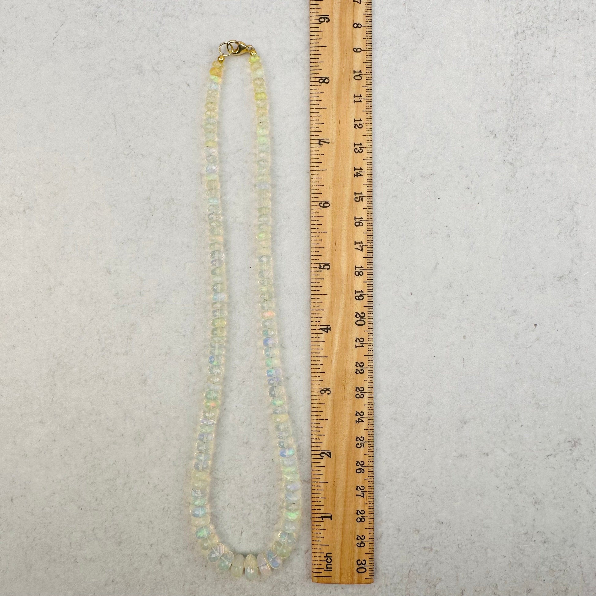necklace next to a ruler for size reference 