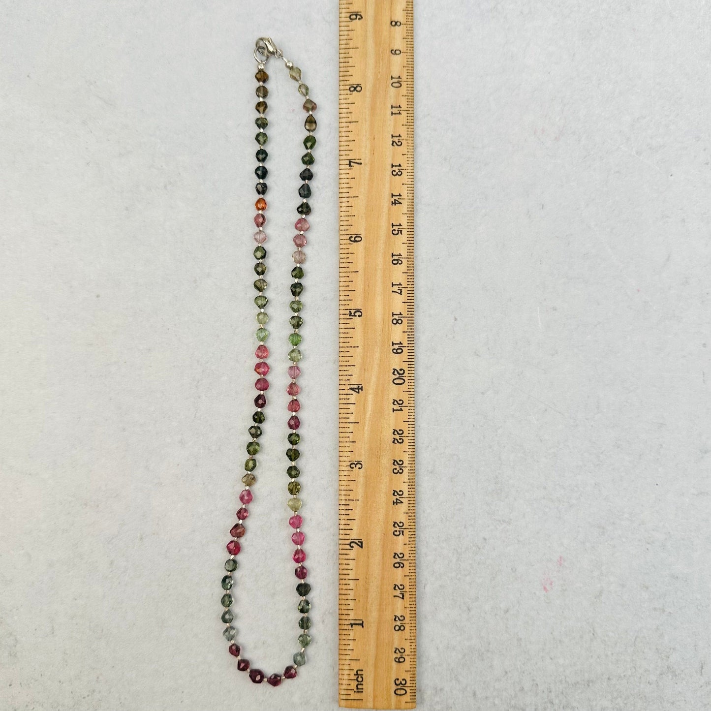 necklace next to a ruler for size reference 