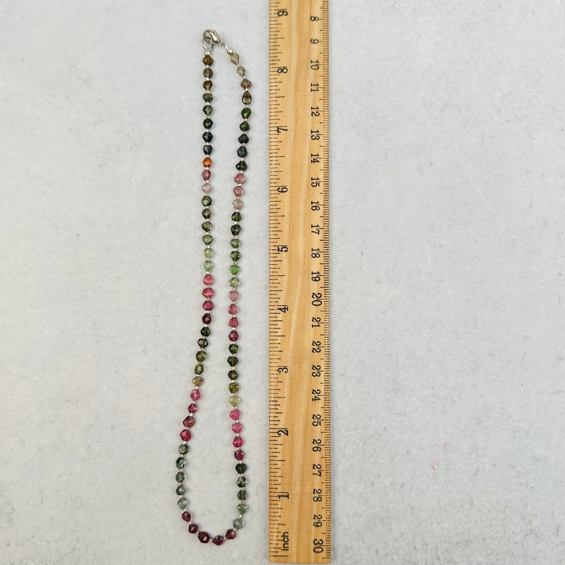necklace next to a ruler for size reference 