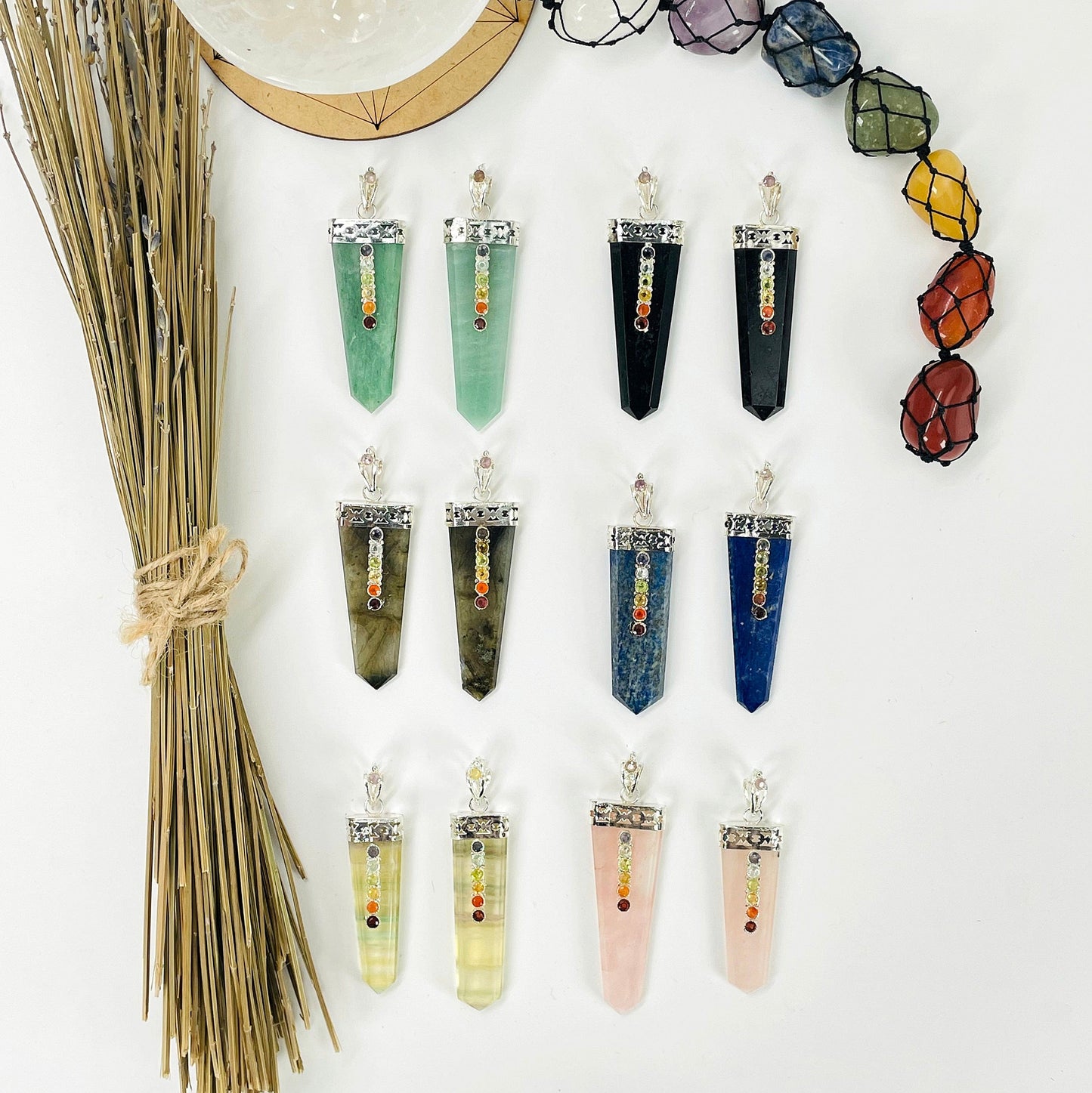 overhead view of two of each polished point pendant options on white background with decorations