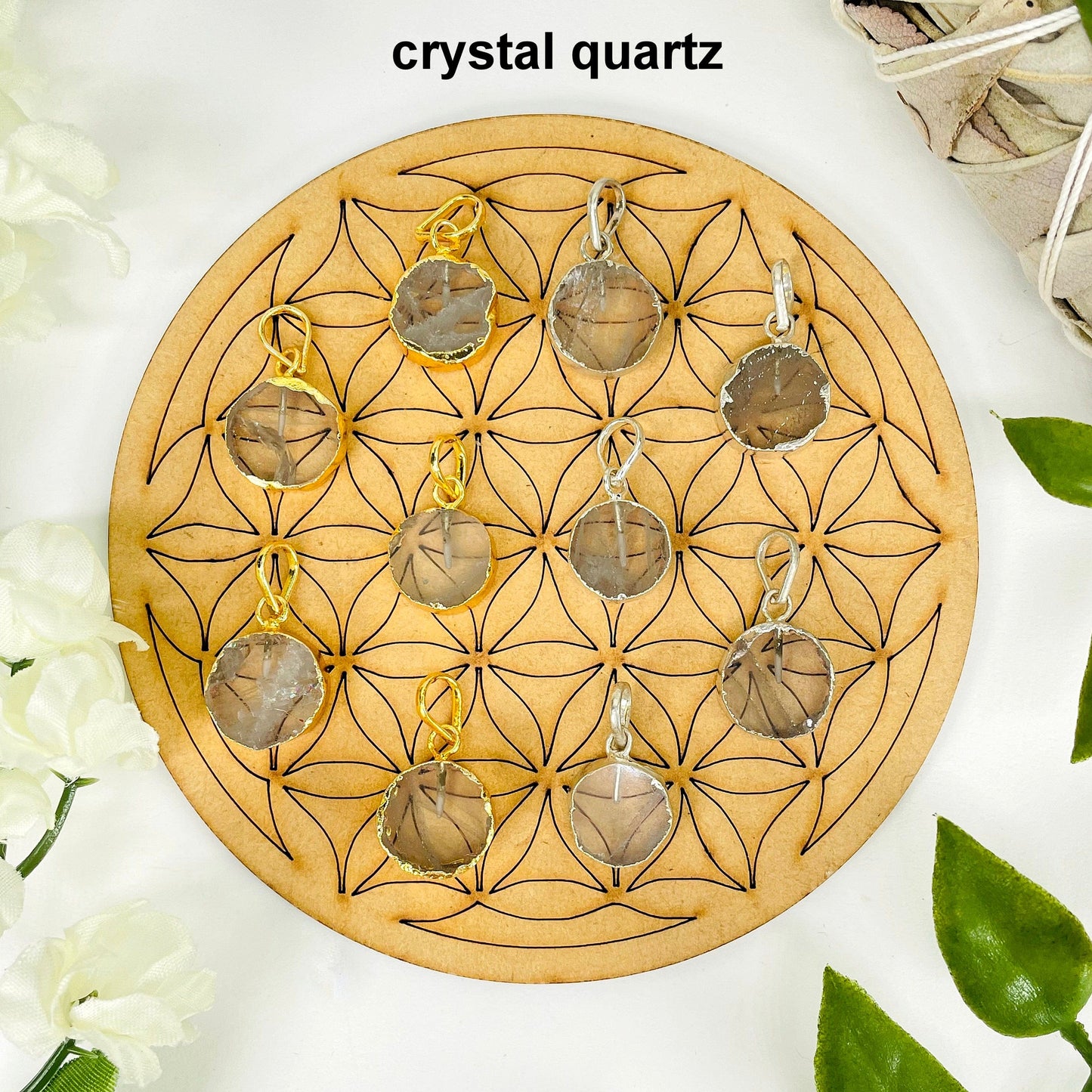 overhead view of five gold and five silver round crystal quartz pendants on display with decorations for possible variations and finish comparison