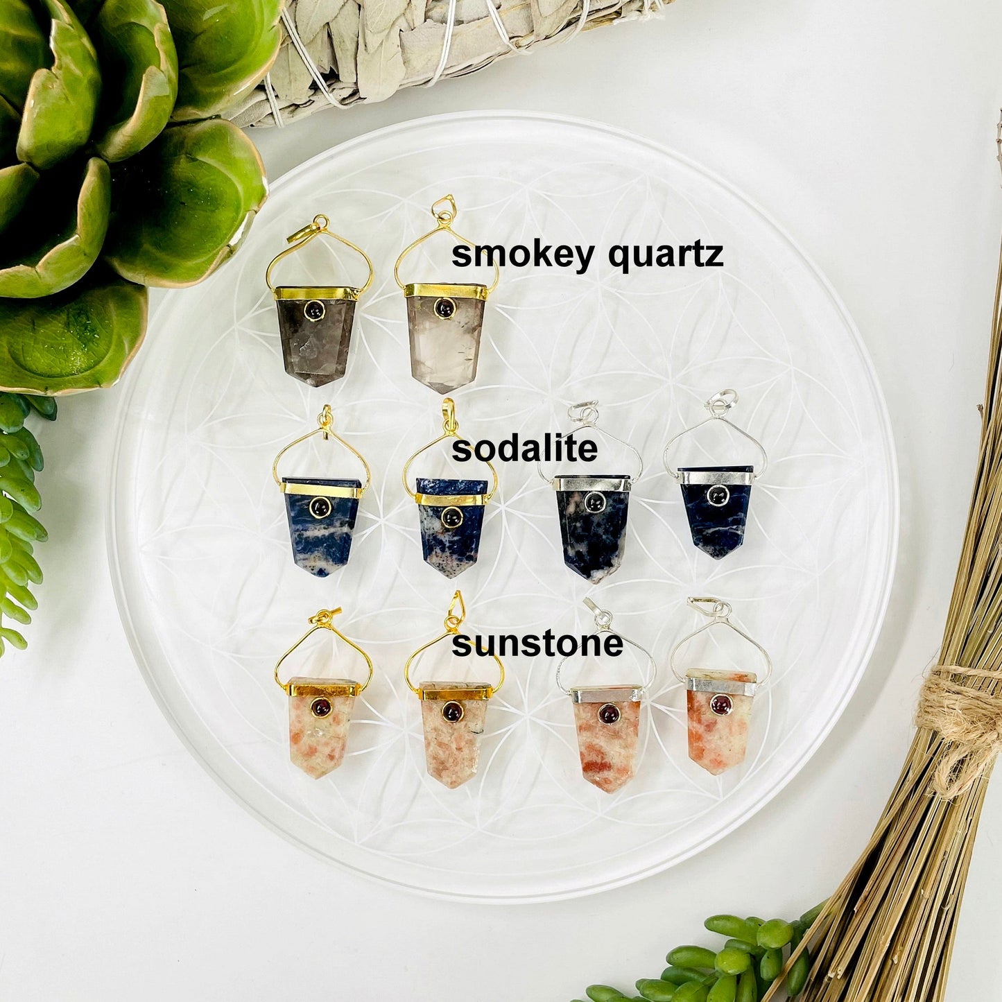overhead view of two gold smokey quartz shield pendants and two gold and two silver sodalite and sunstone shield pendants
