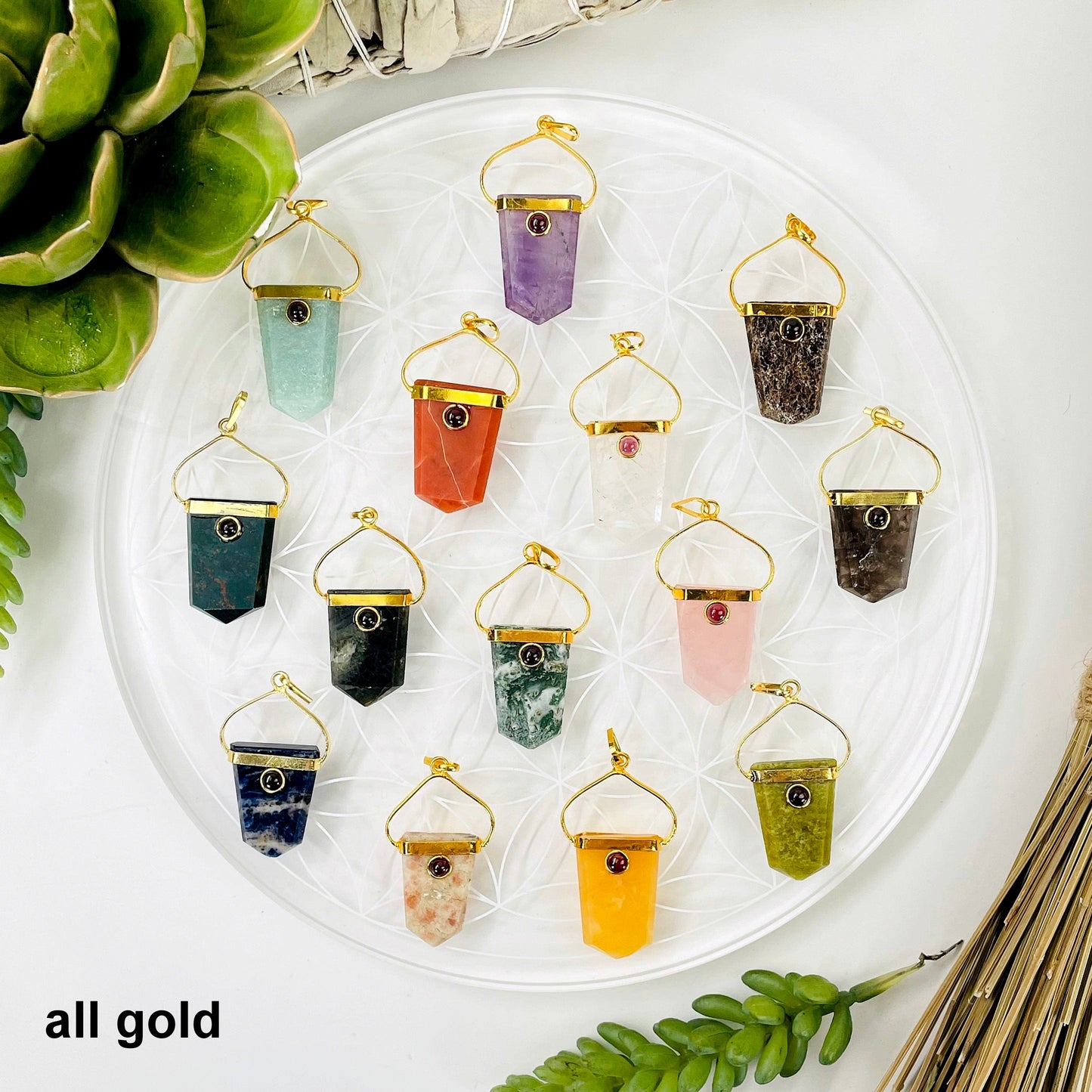 overhead view of one of each shield pendant options in gold 