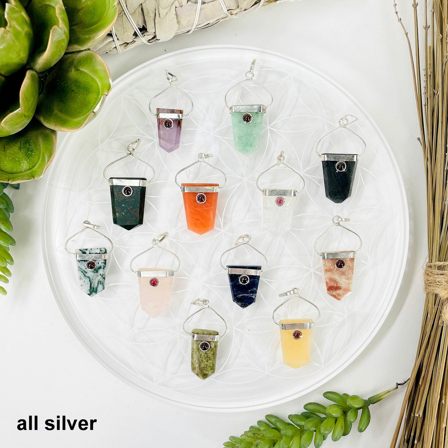 overhead view of one of each shield pendant options in silver