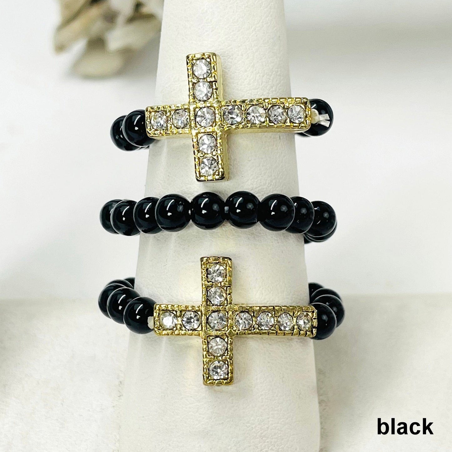 close up of three black sideways cross elastic rings on ring display