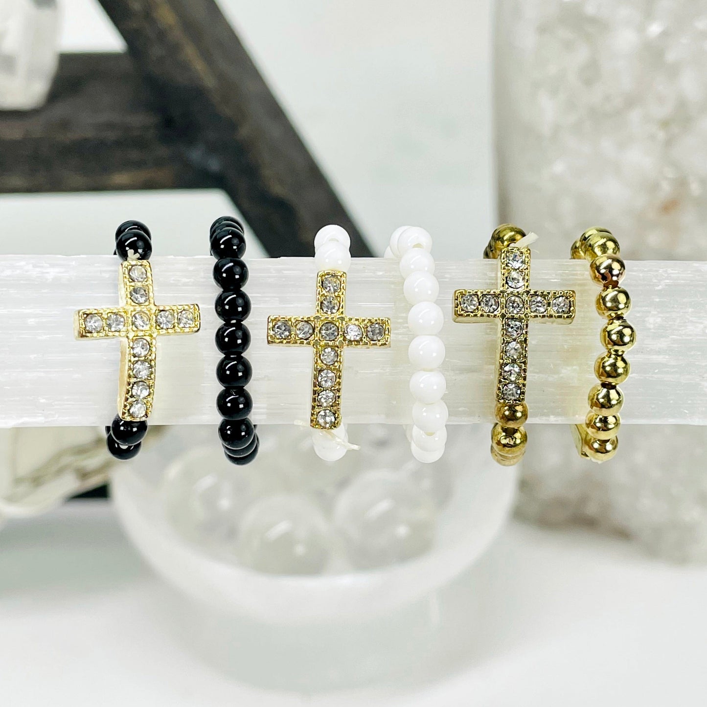 close up two of each sideways cross elastic ring options on selenite bar for color comparison and details