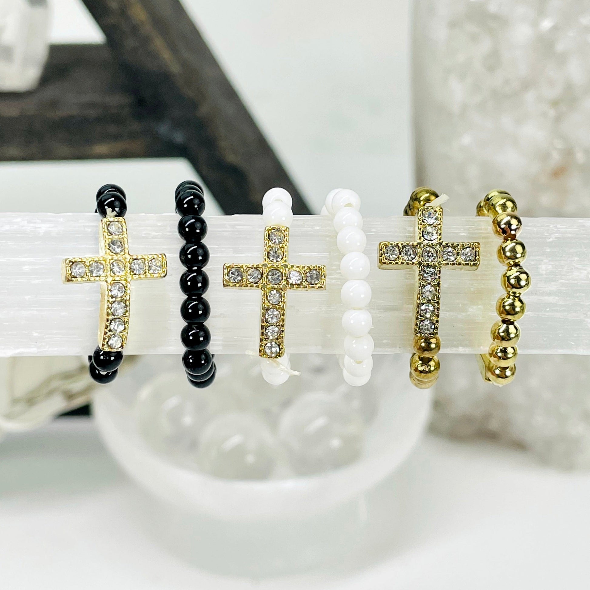 close up two of each sideways cross elastic ring options on selenite bar for color comparison and details