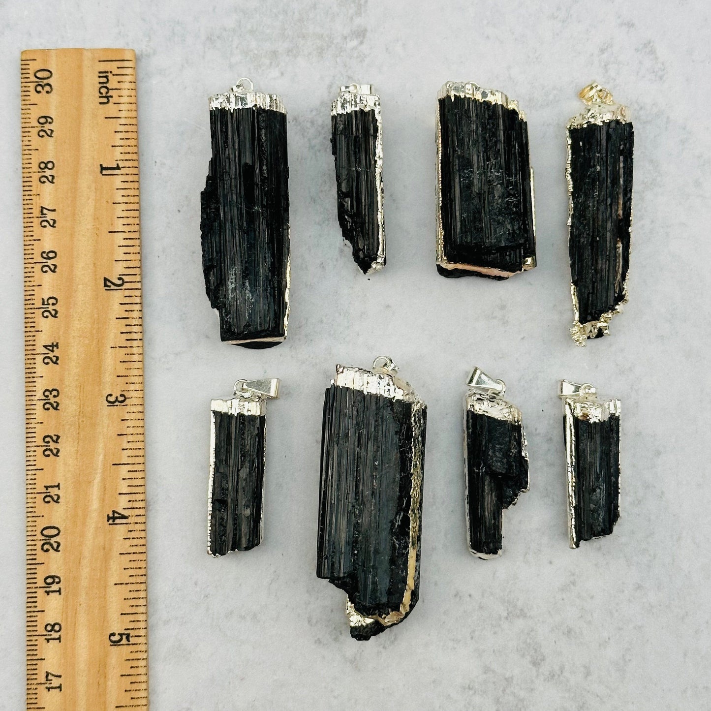 pendants next to a ruler for size reference 