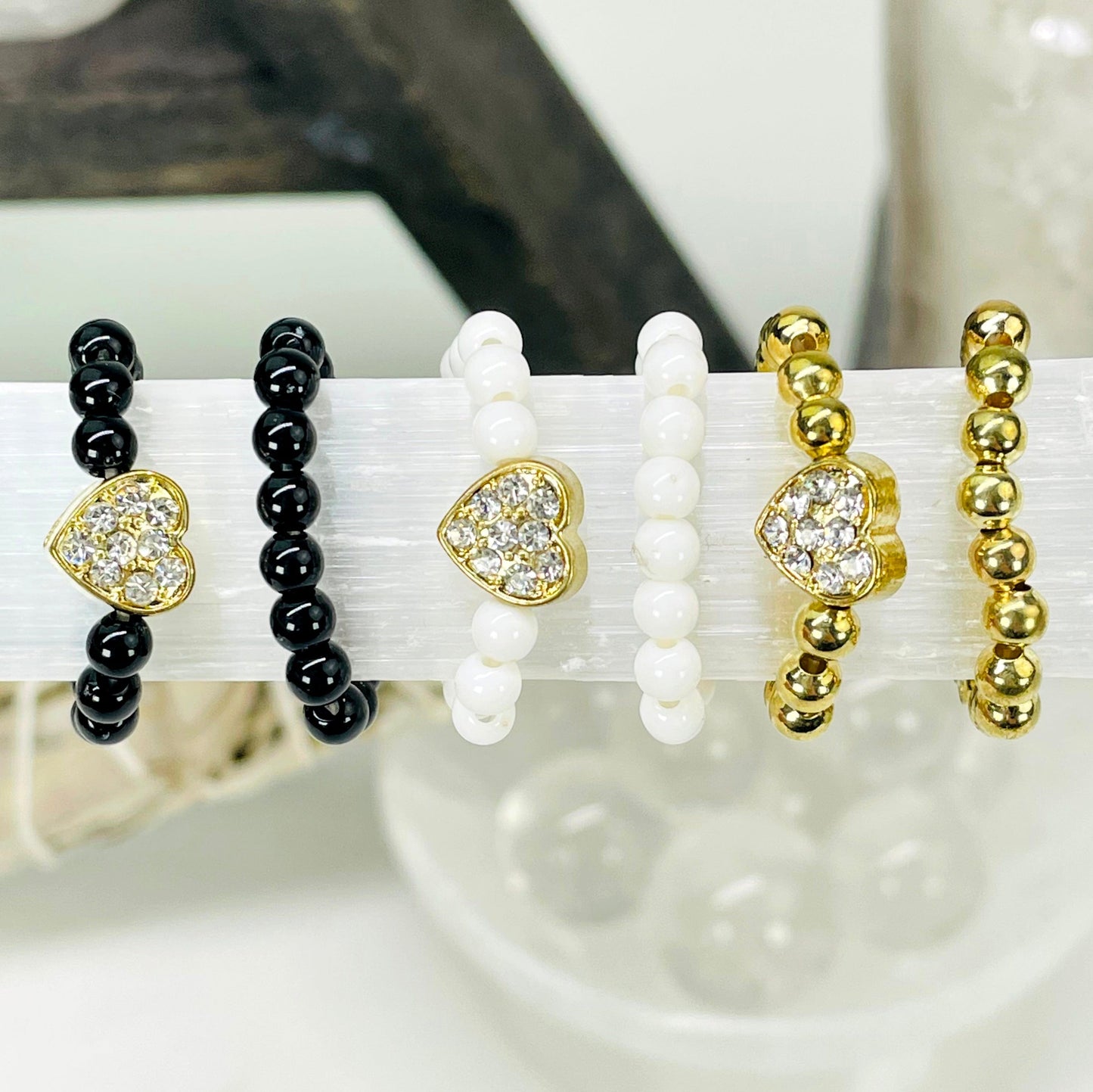 close up two of each heart elastic ring options on selenite bar for color comparison and details