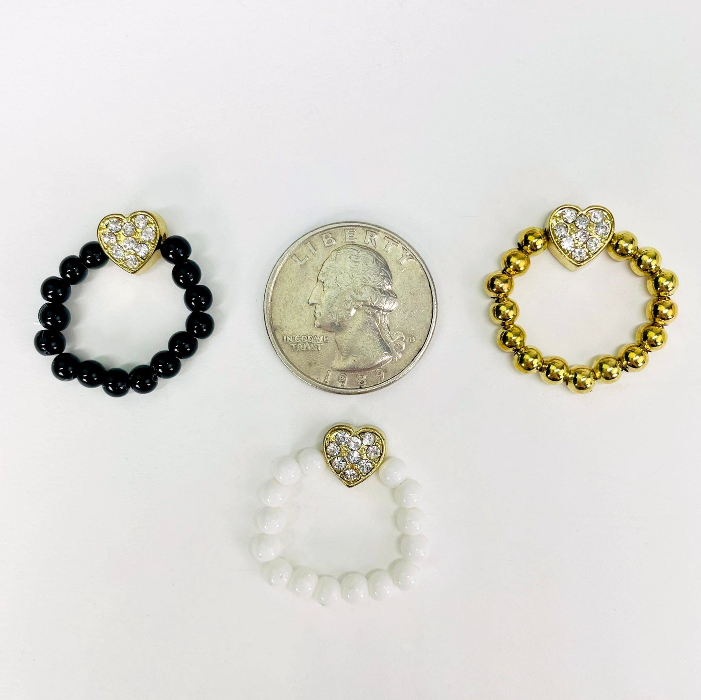 overhead view of one of each heart elastic ring colors with a quarter for size reference