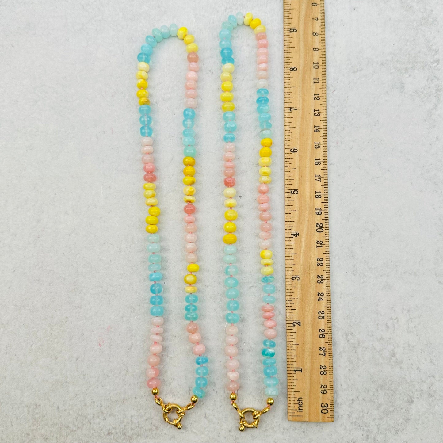 necklaces next to a ruler for size reference 