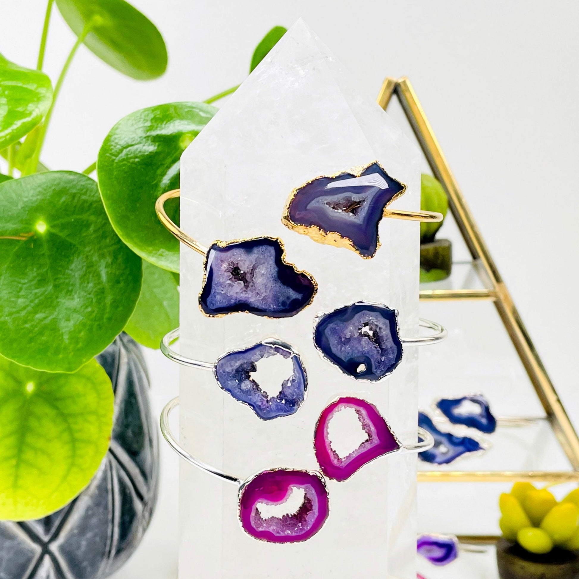 one of each double agate adjustable bracelet options on a crystal quartz point in front of background decorations