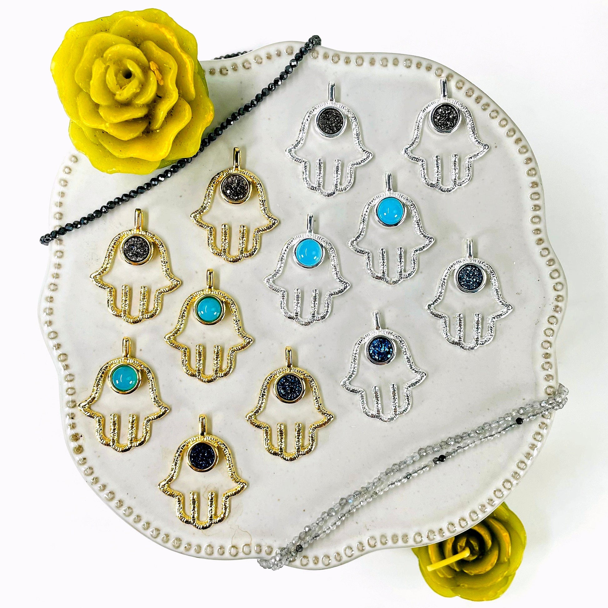 overhead view of two of each hamsa hand pendant options on display