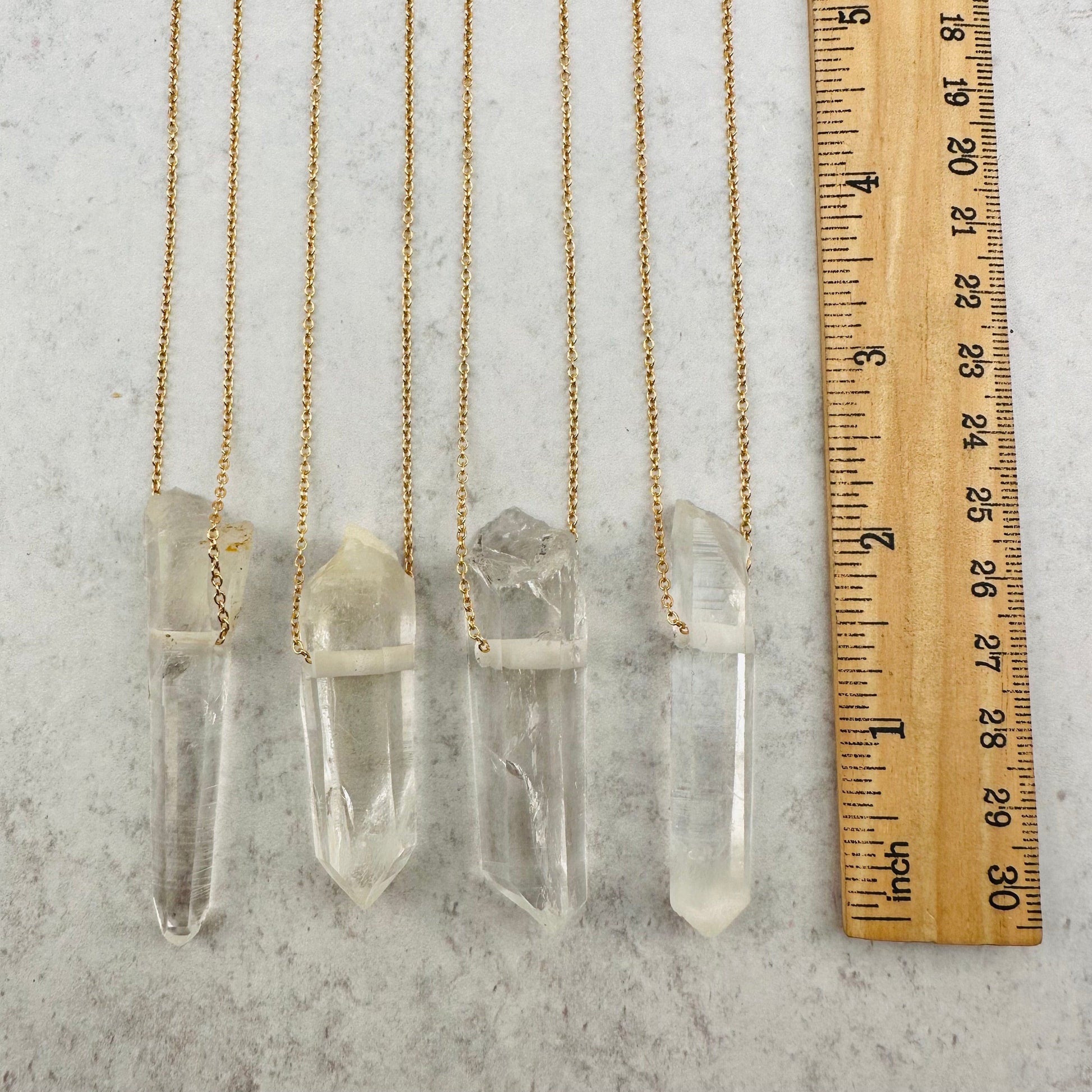 pendants next to a ruler for size reference 