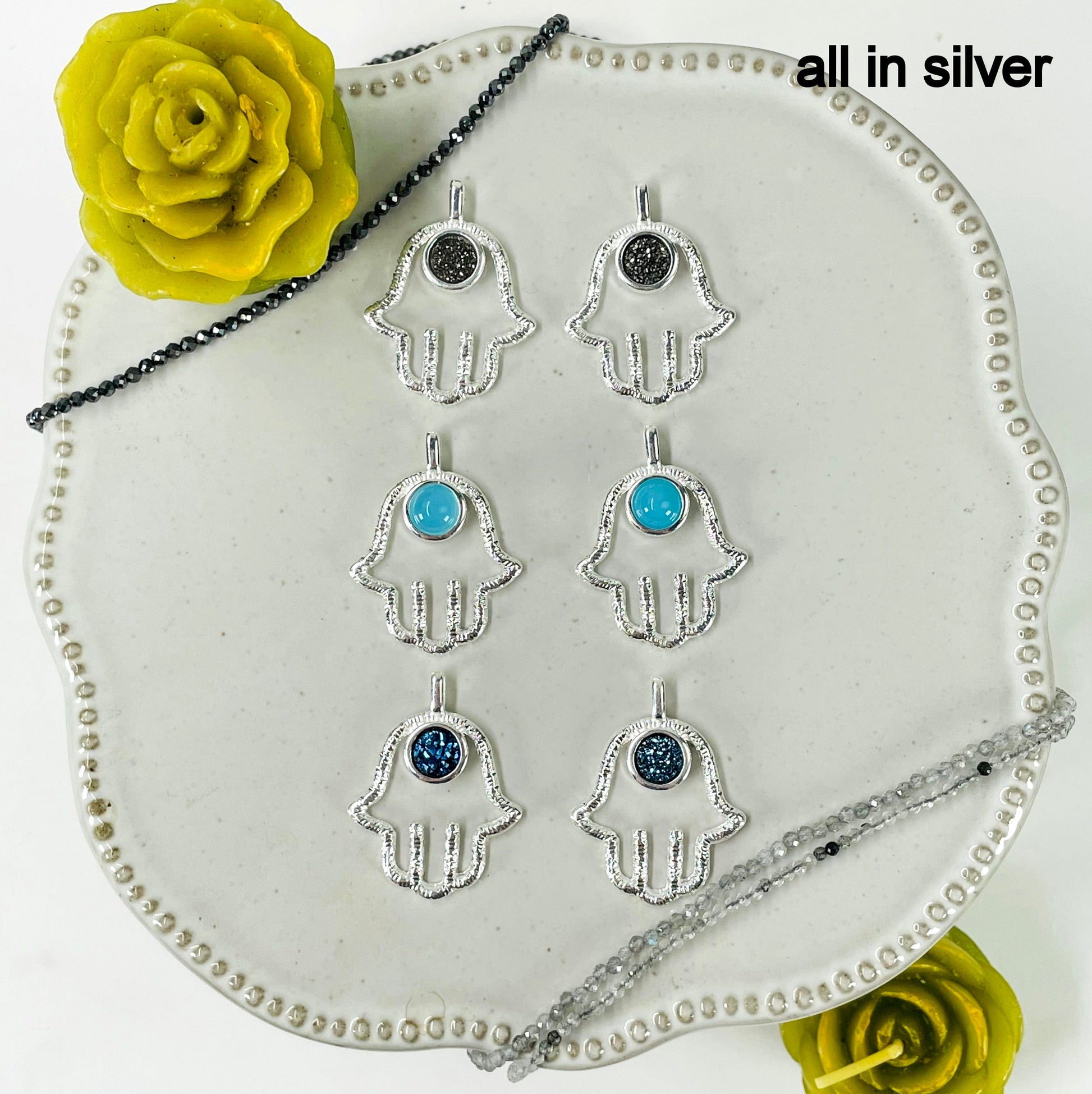 overhead view of two of each silver hamsa hand pendant stone options for finish reference