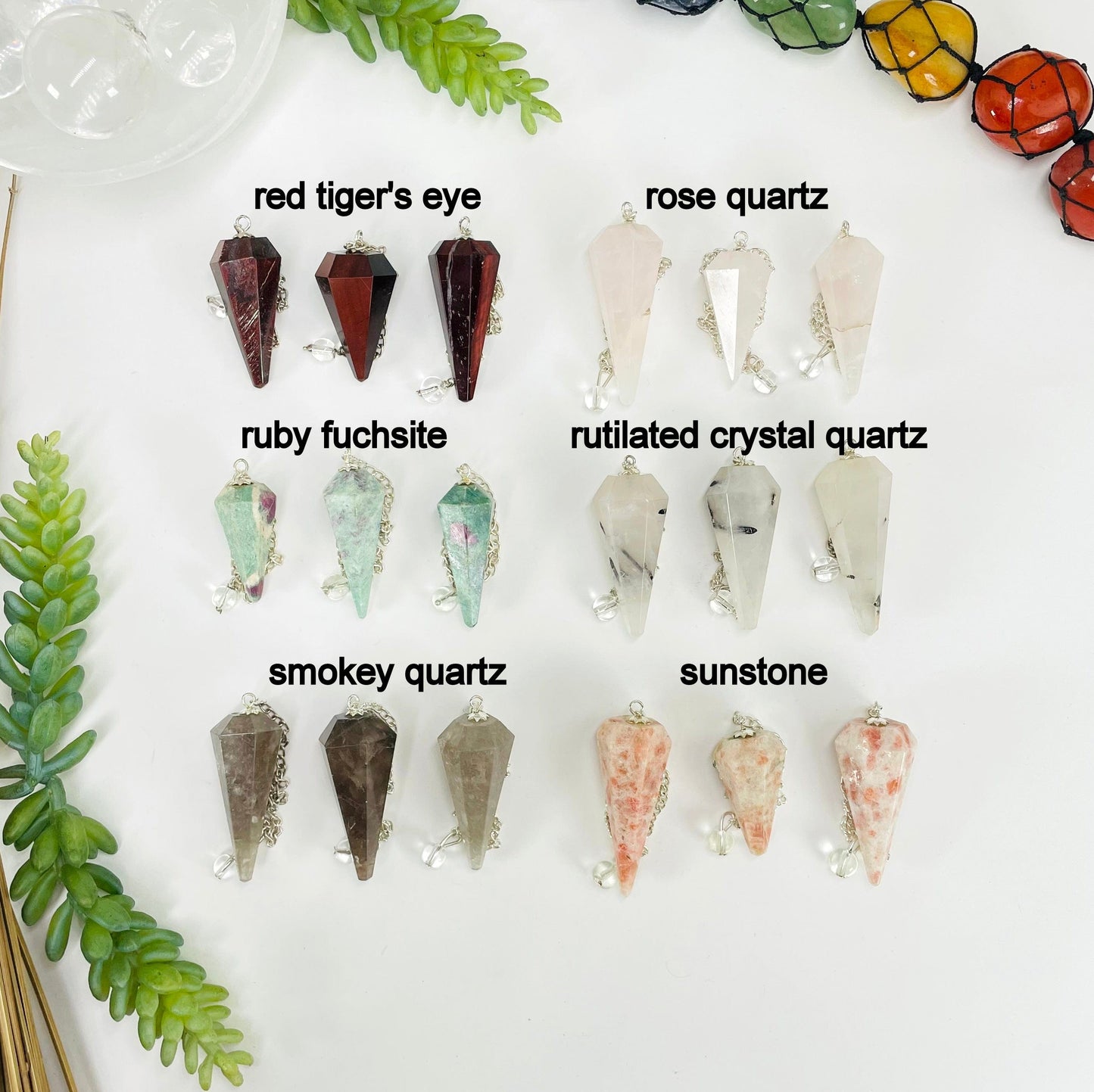 three red tiger's eye, rose quartz, ruby fuchsite, rutilated crystal quartz, smokey quartz, and sunstone pendulum pendants on white background for possible variations 