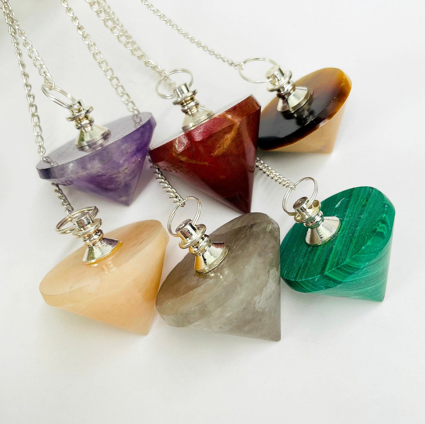close up of six different pendulum pendants on white background for details