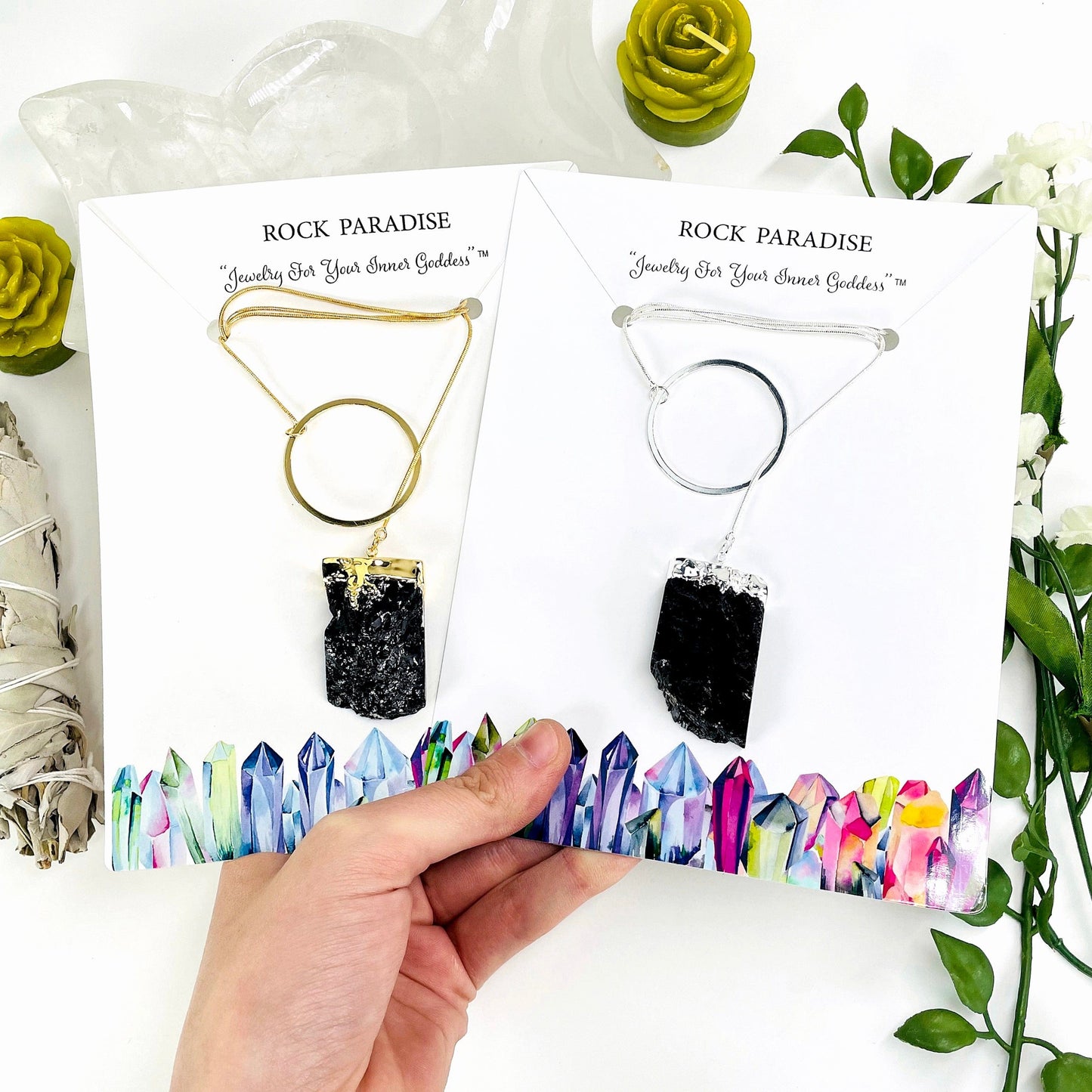 one gold and one silver obsidian chunk adjustable necklace in their packaging in hand for size reference and finish comparison