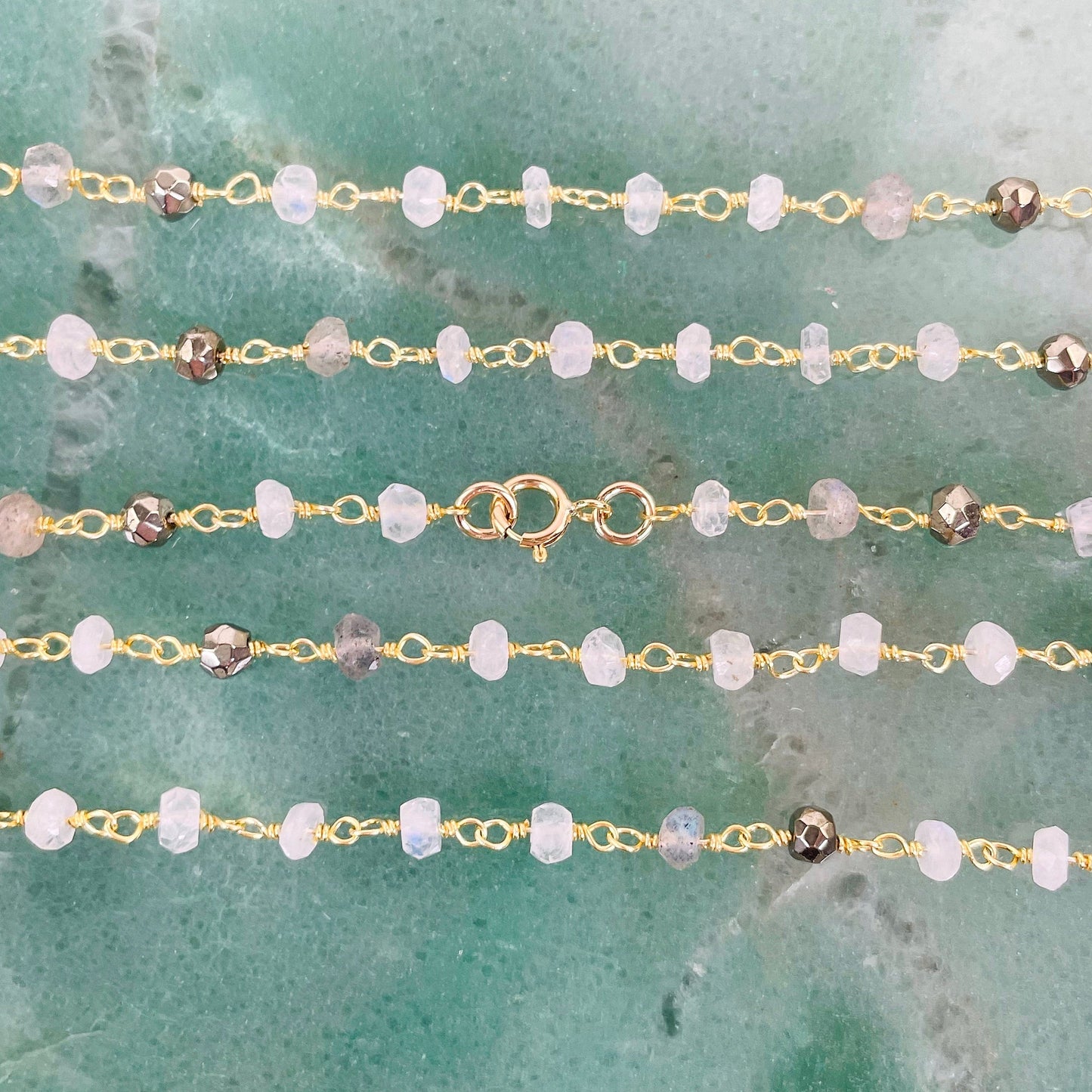 close up of necklace chain and clasp on green background