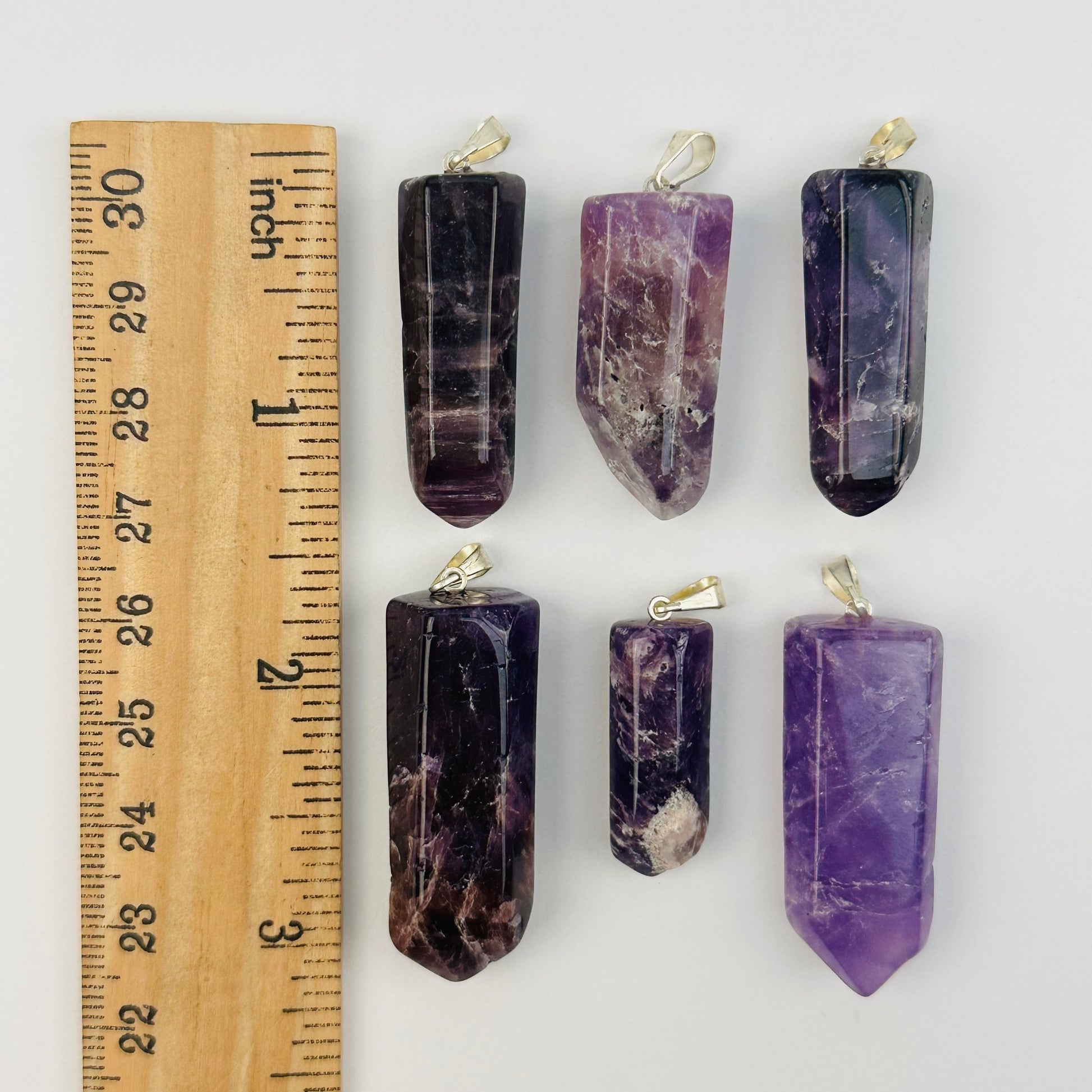 pendants next to a ruler for size reference 