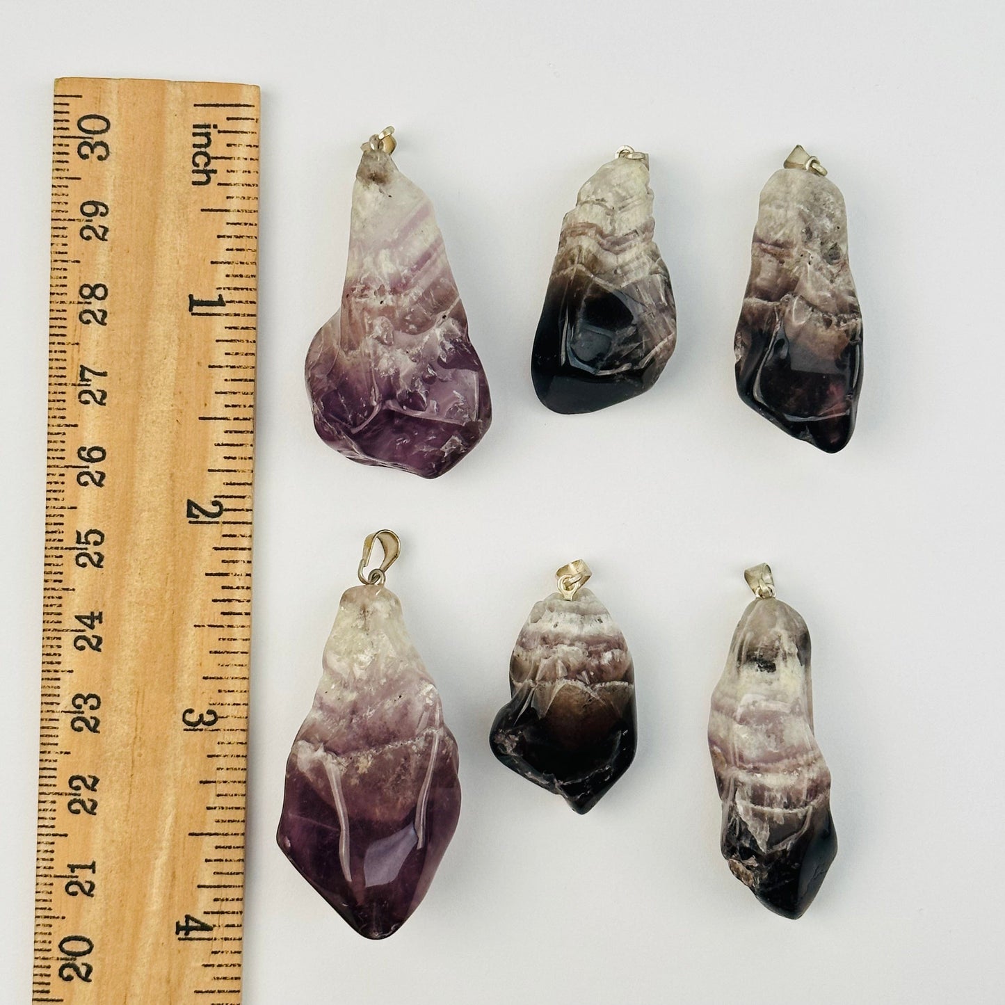 pendants next to a ruler for size reference 