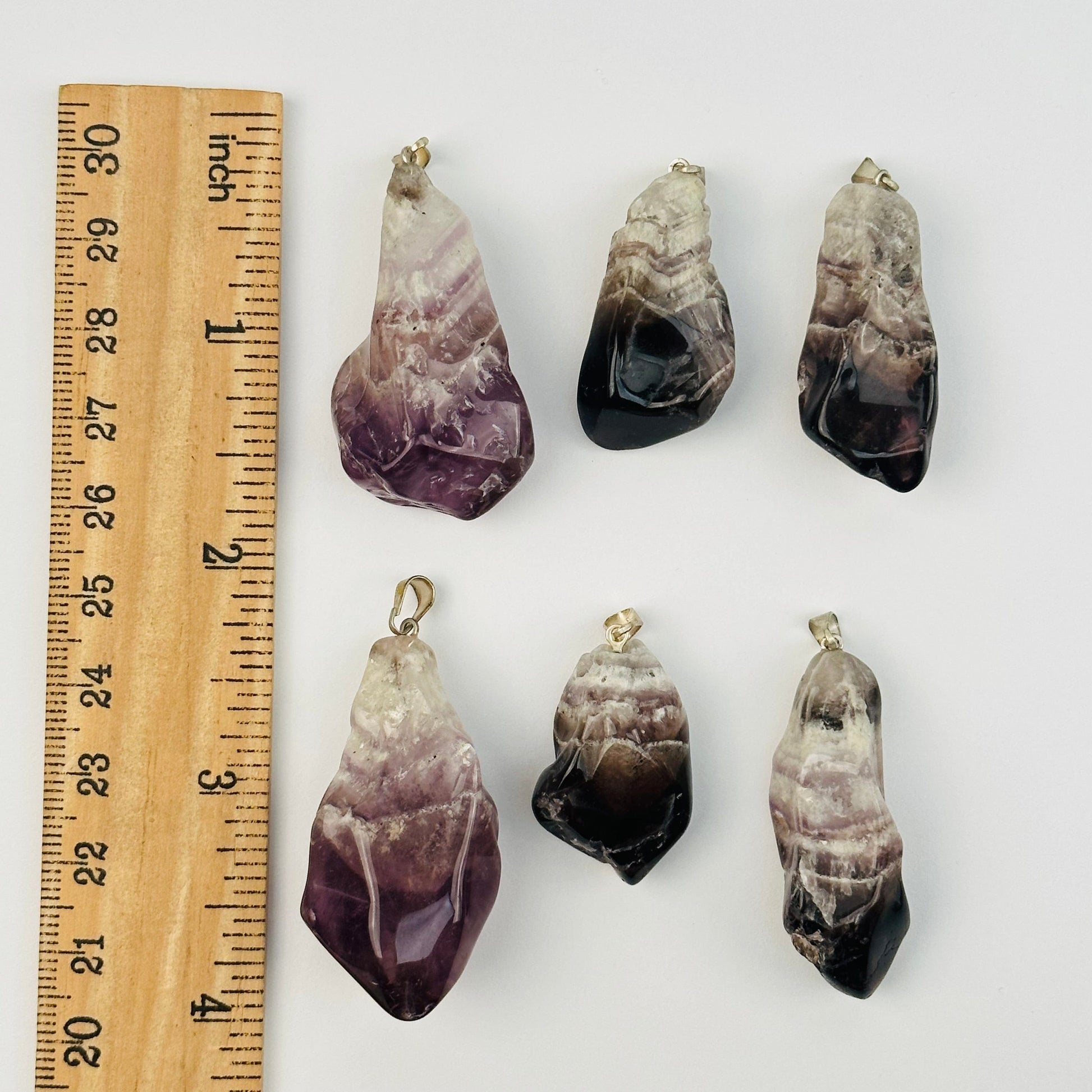 pendants next to a ruler for size reference 