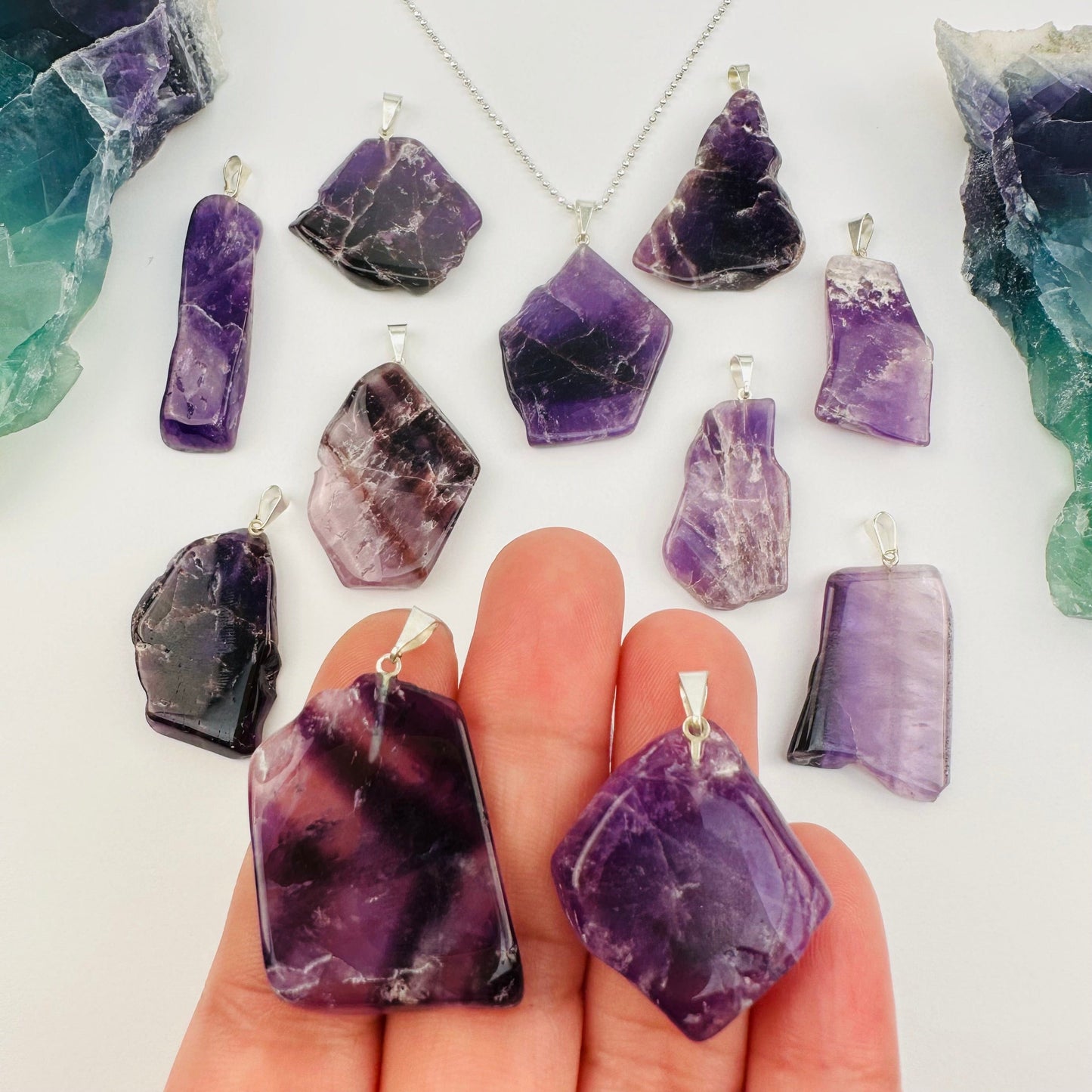 Amethyst Crystal Polished Slice Pendant - Silver Toned Bail in hand for size reference 