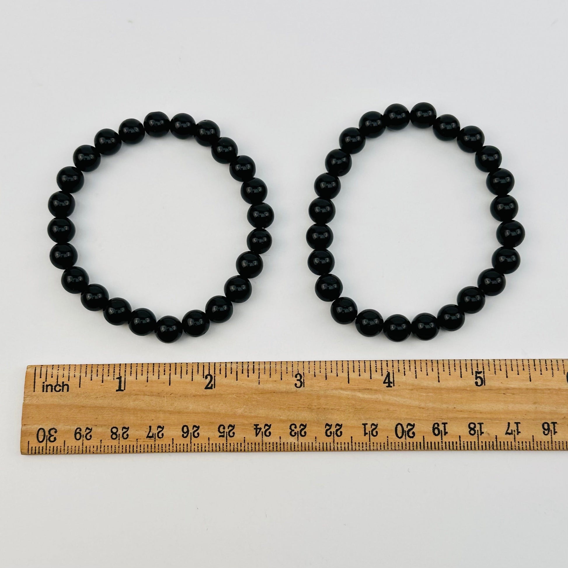 black tourmaline bracelets next to a ruler for size reference 