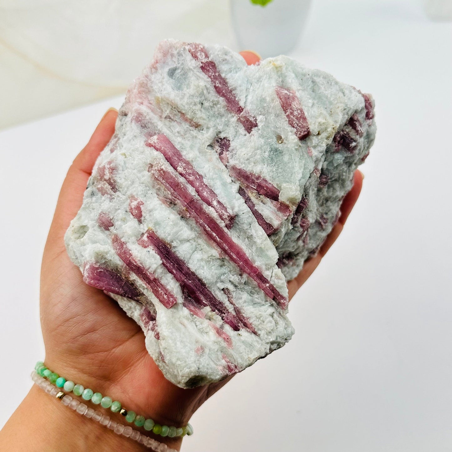 large pink tourmaline crystal cluster in hand for size reference 