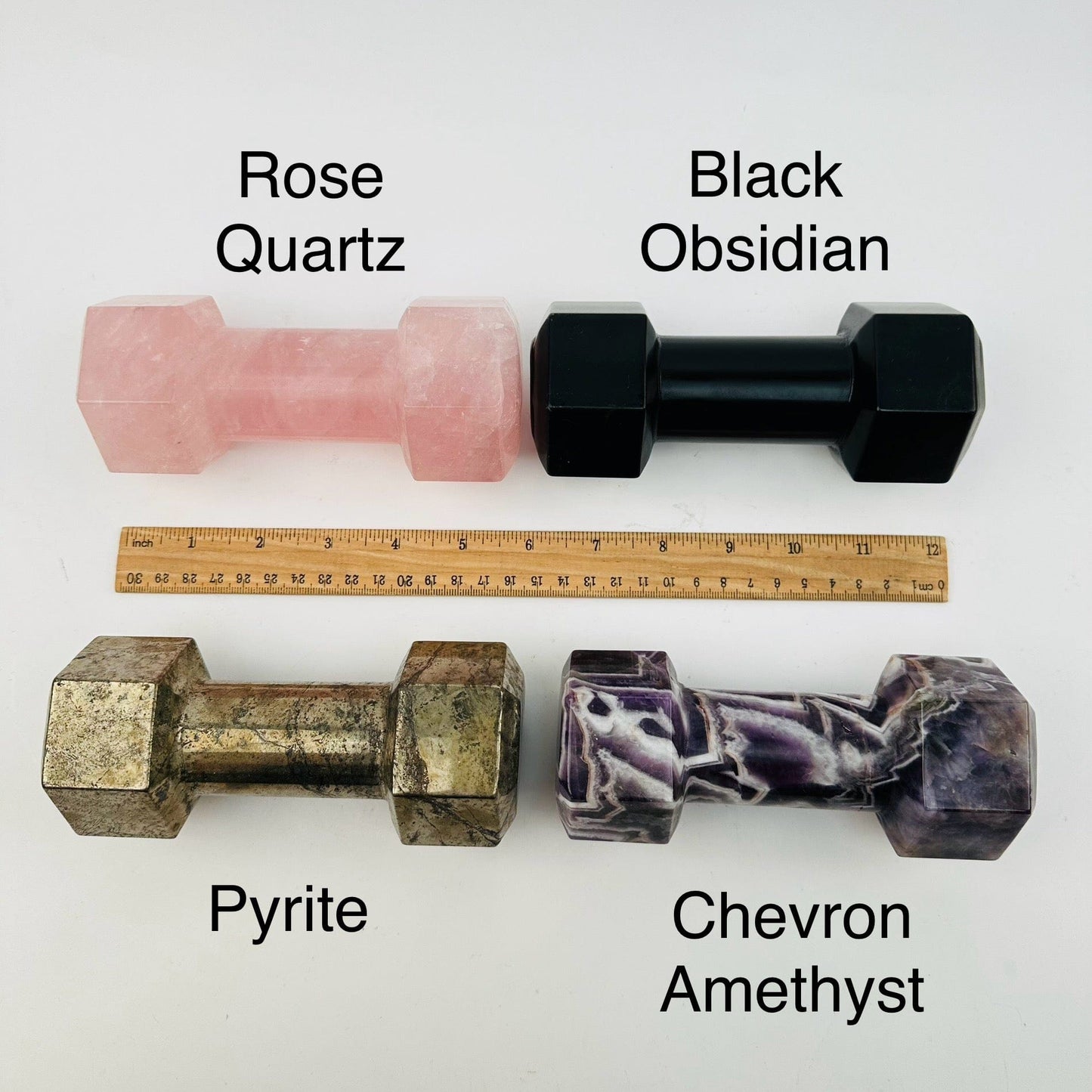 crystal dumbbells displayed next to a ruler for size reference 