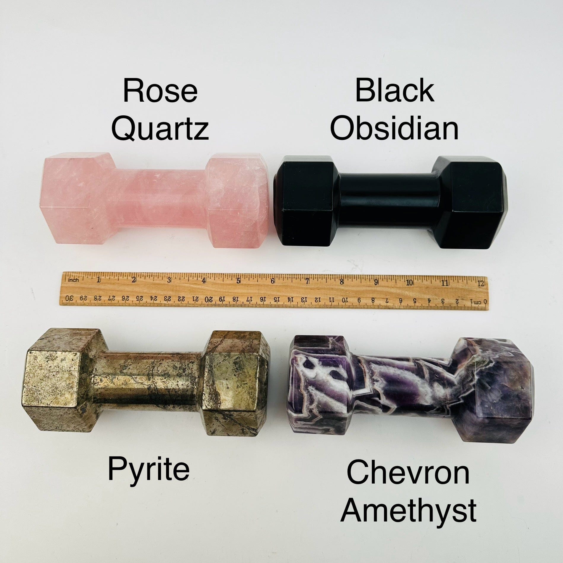 crystal dumbbells displayed next to a ruler for size reference 