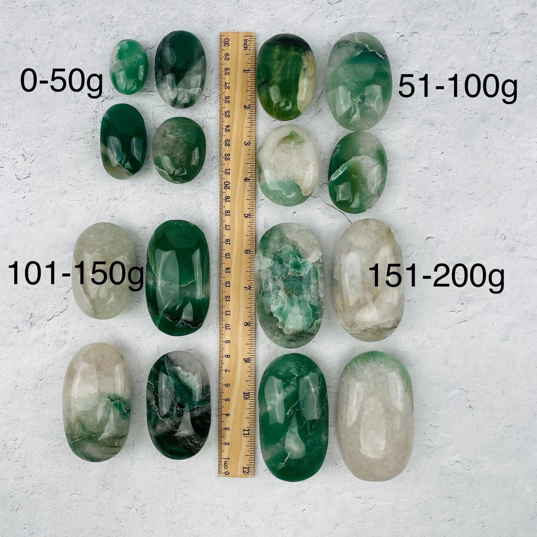 palm stones sold by weight. displayed next to a ruler for size reference 