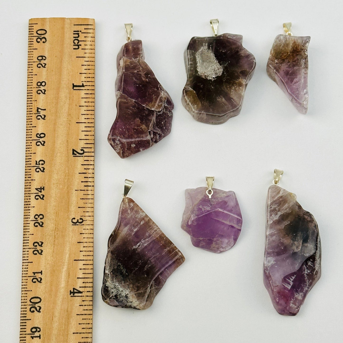 pendants displayed next to a ruler for size reference 