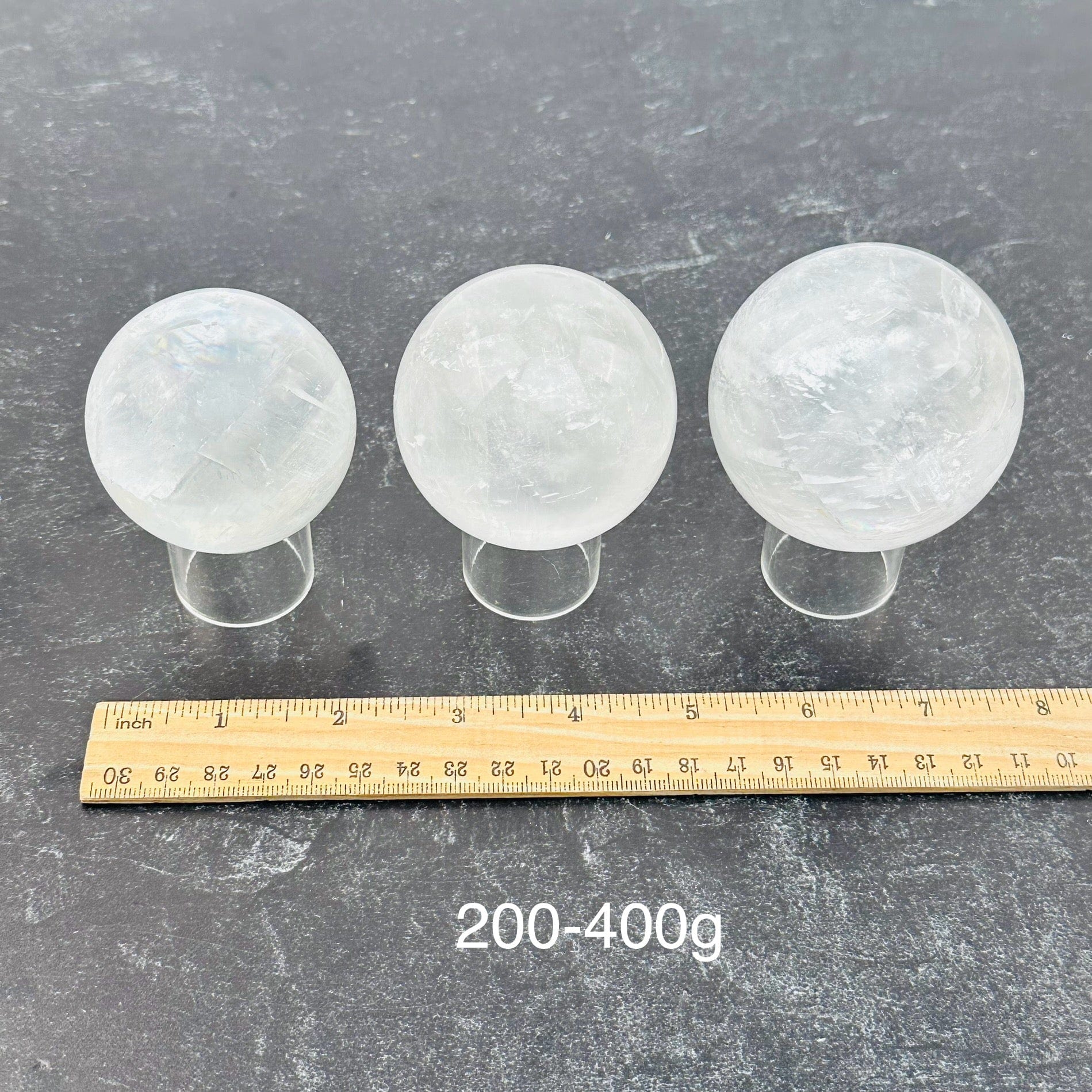 calcite crystal spheres sold by the weight. displayed next to a ruler for size reference 