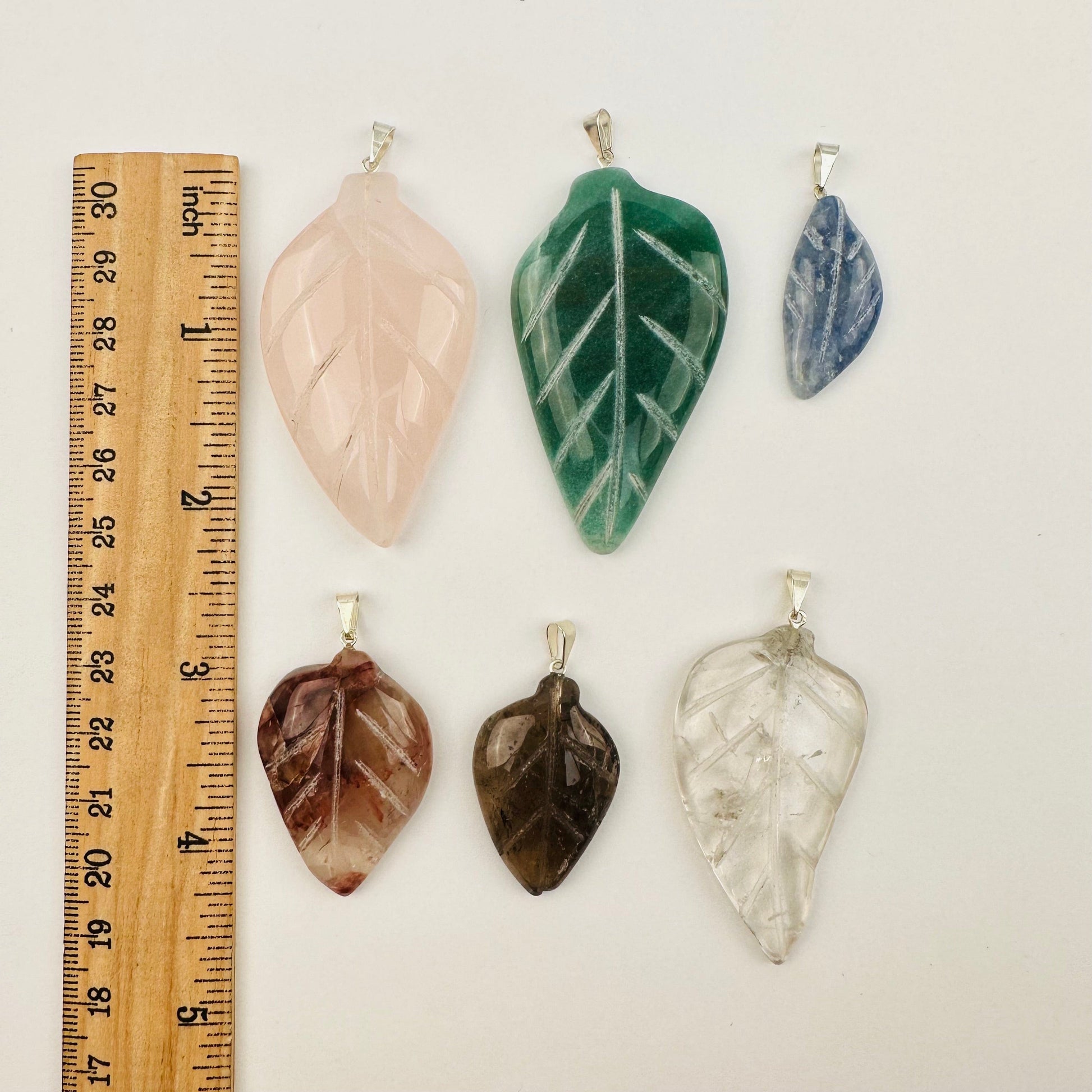 pendants next to a ruler for size reference 