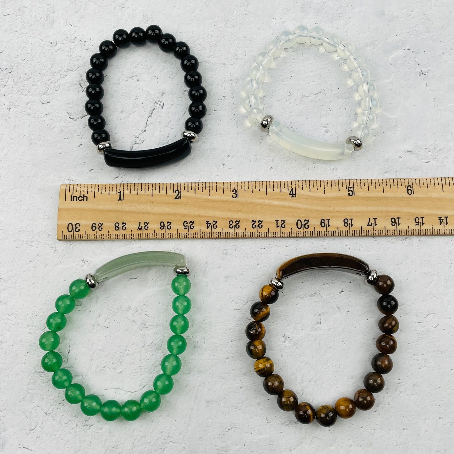bracelets next to a ruler for size reference 