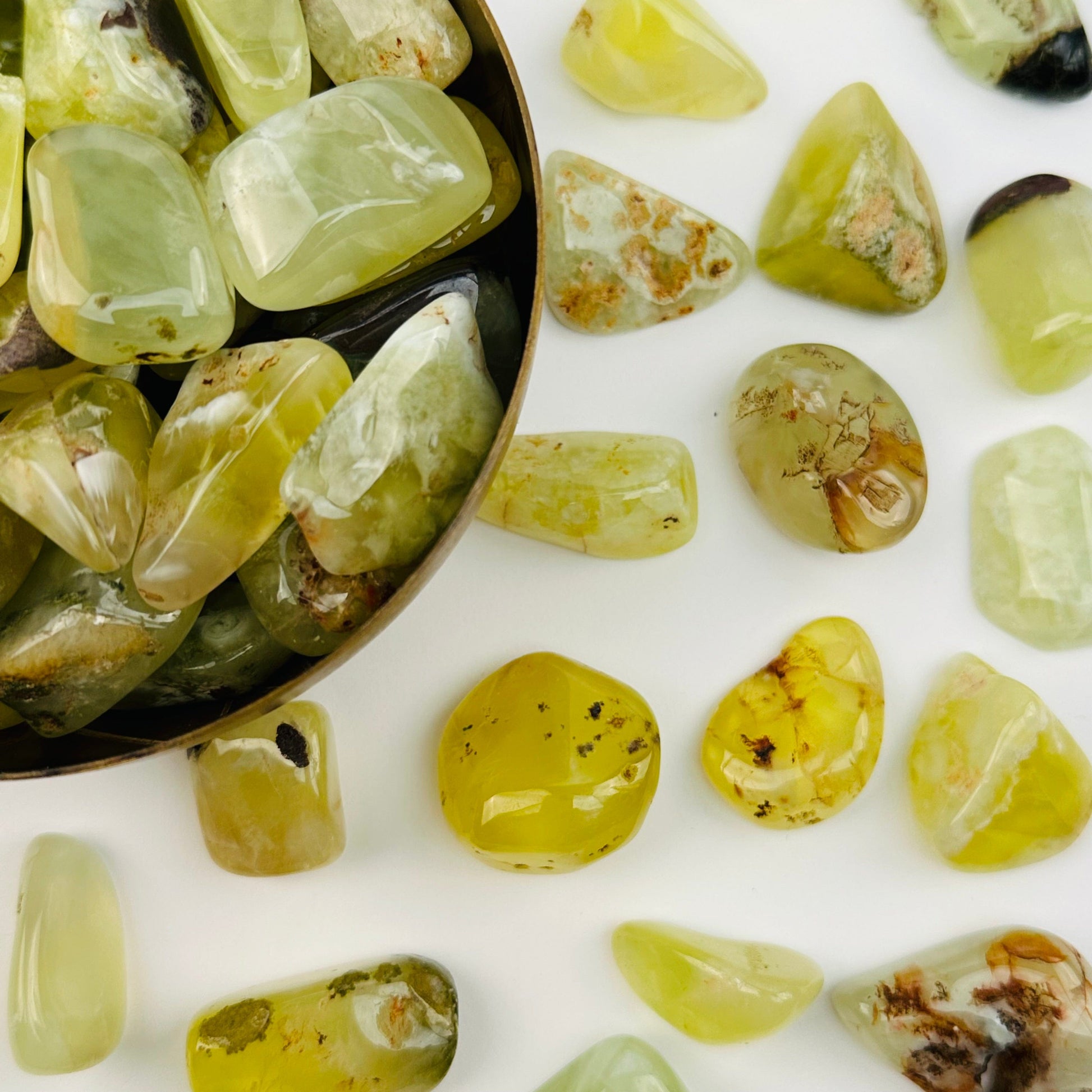 multiple tumbled stones displayed to show the differences in the sizes and color shades 