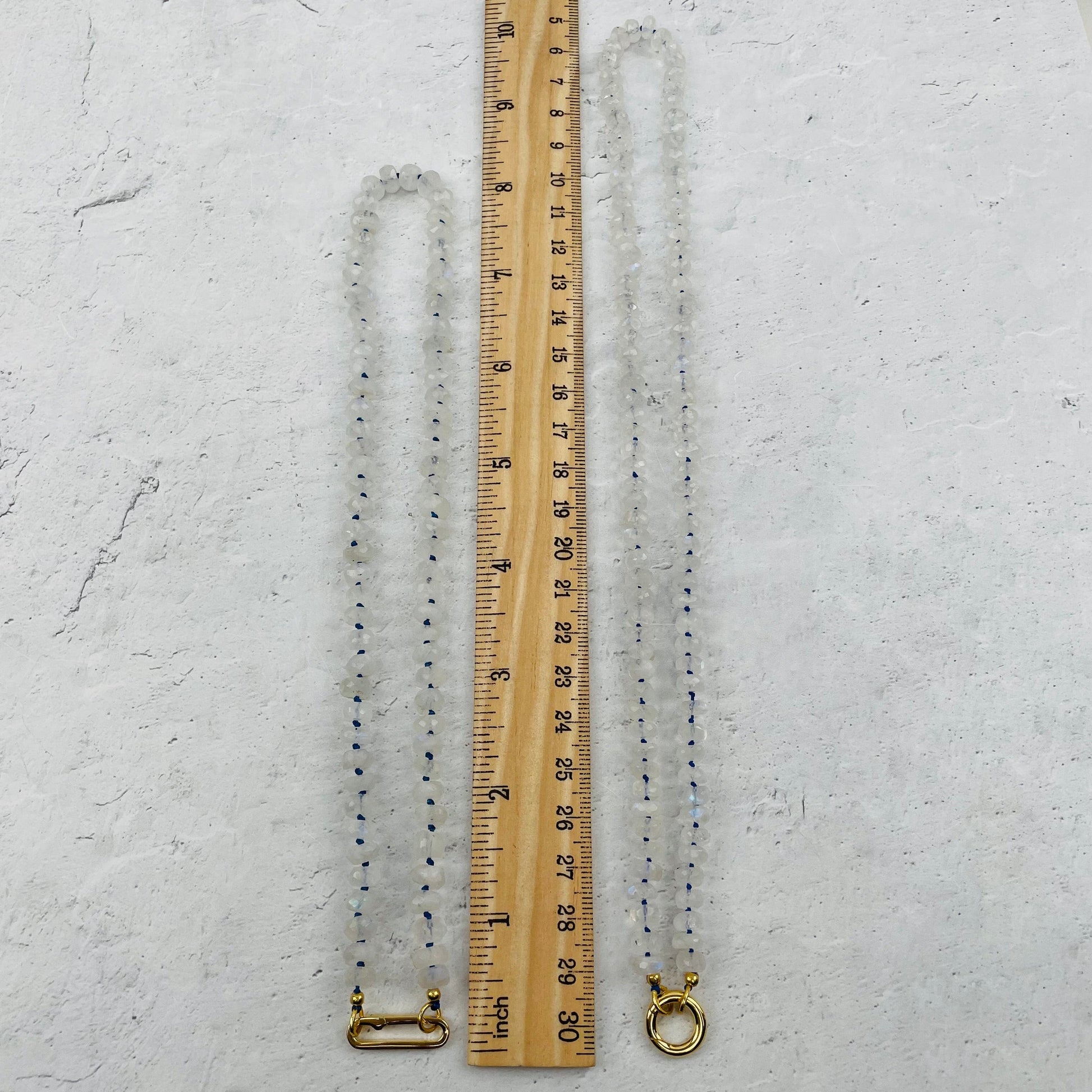 necklace next to a ruler for size reference 