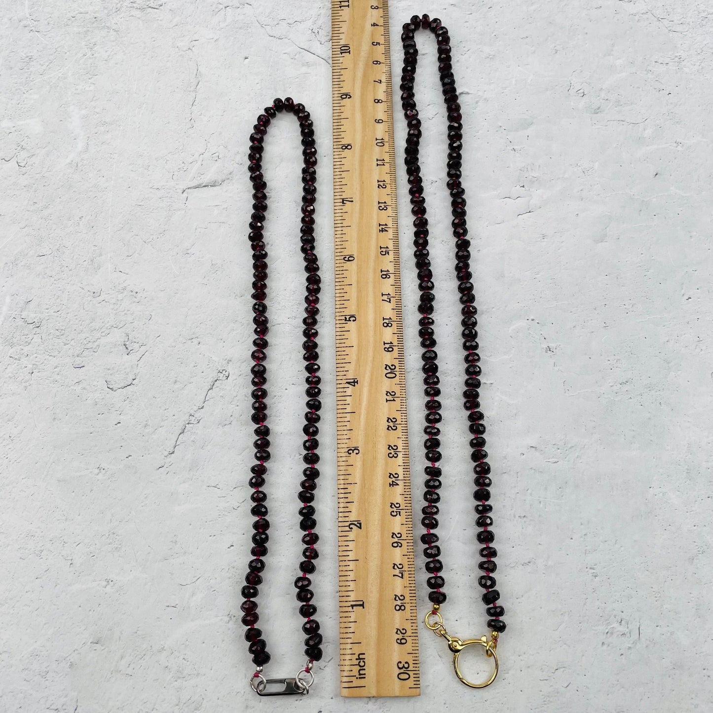 necklace next to a ruler for size reference 