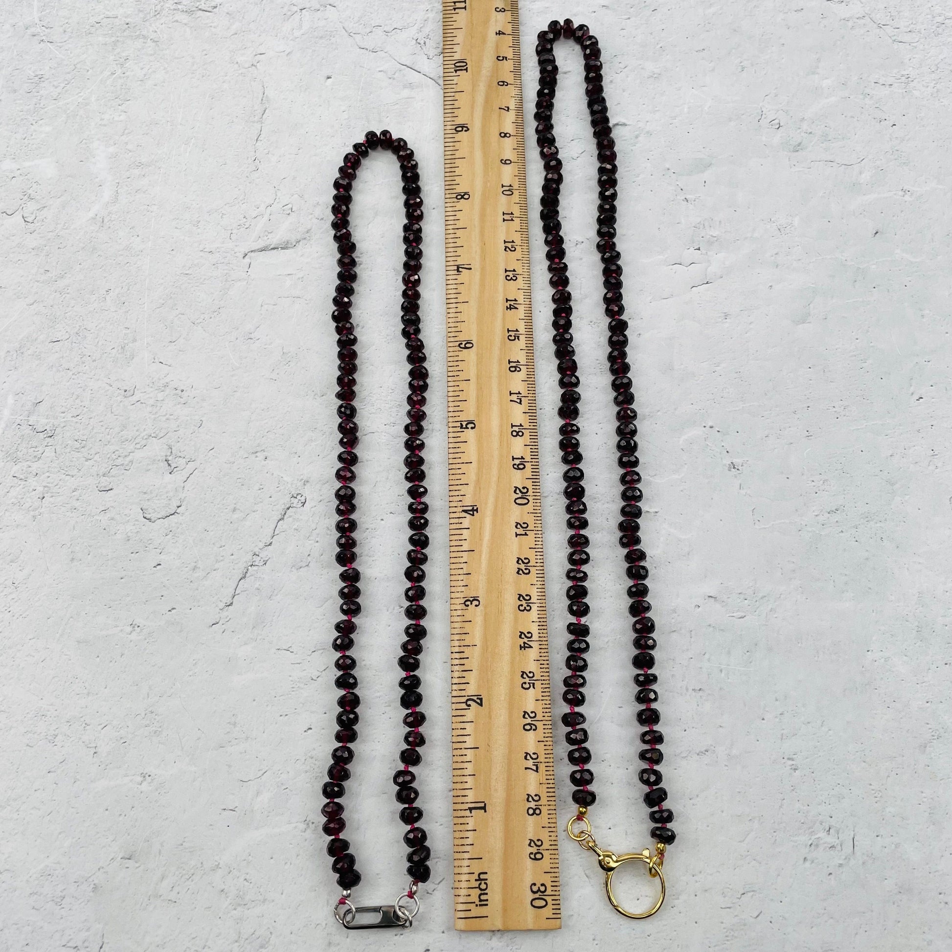 necklace next to a ruler for size reference 