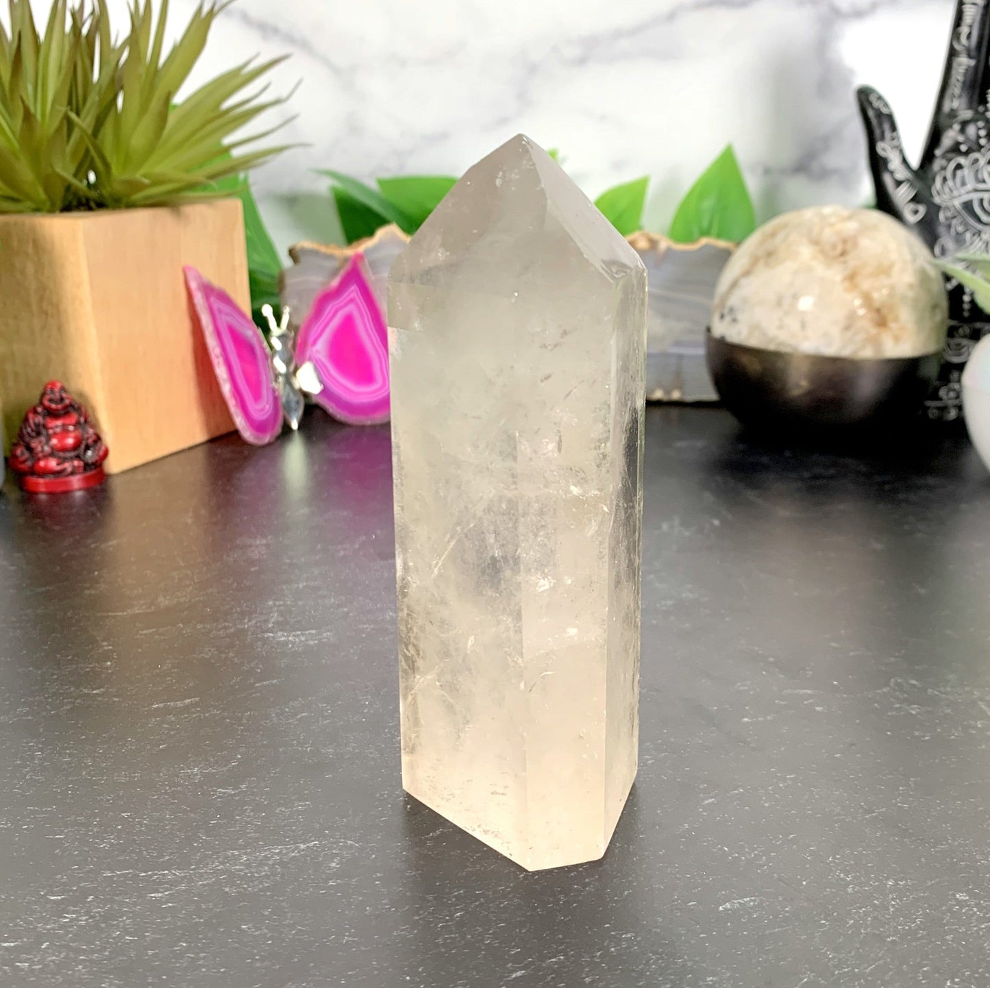 Crystal Quartz Tower Point with decorations in the background