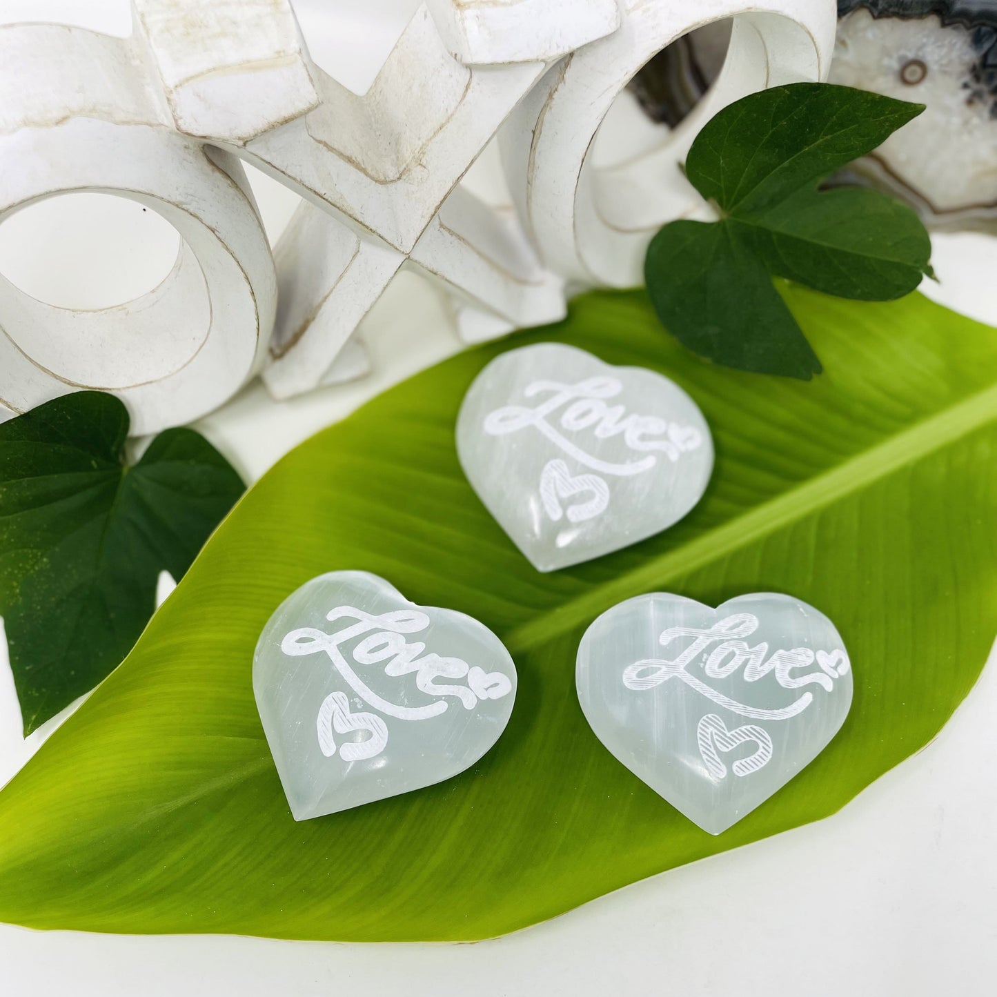 selenite engraved "love" heart stones on display