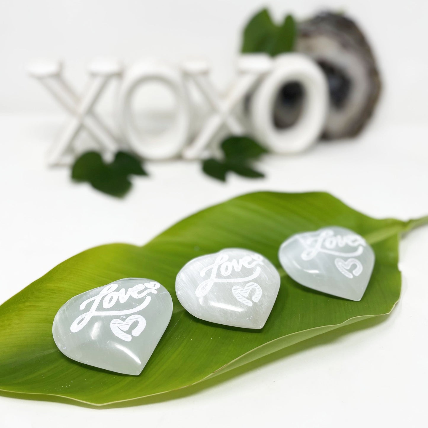 selenite engraved "love" heart stones on display