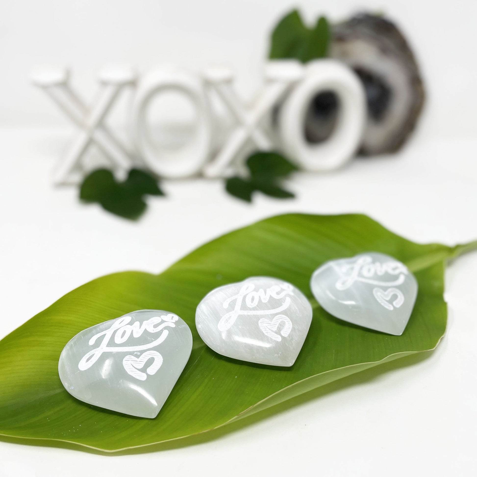 selenite engraved "love" heart stones on display