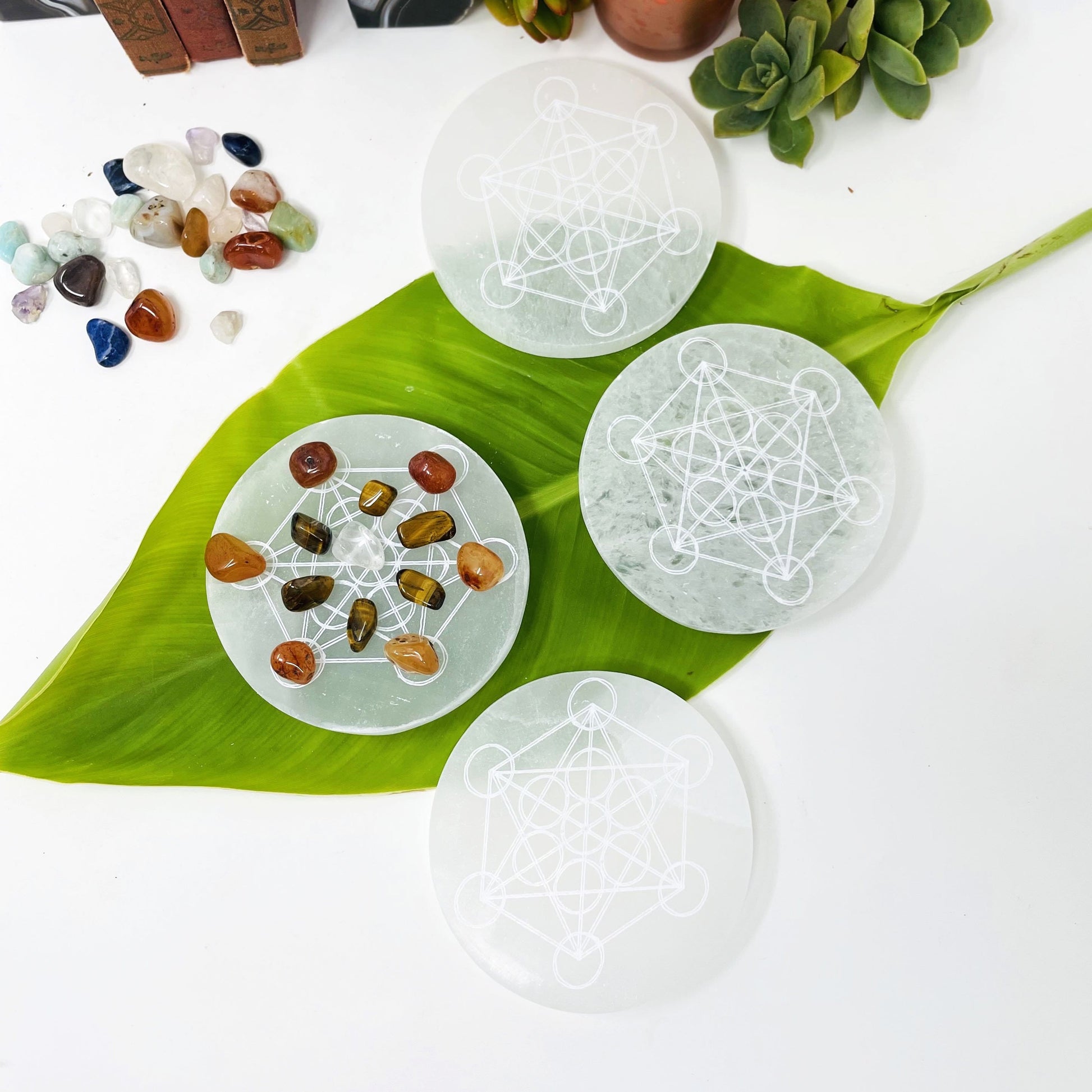 overhead view of selenite rounds with metatron engraving on display for engraving details and possible variations
