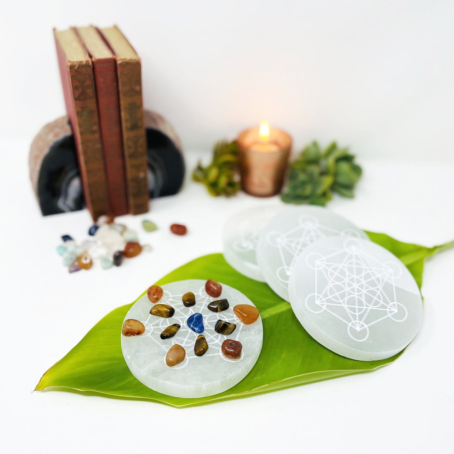 selenite round with metatron engraving with charging stones and other selenite rounds on display